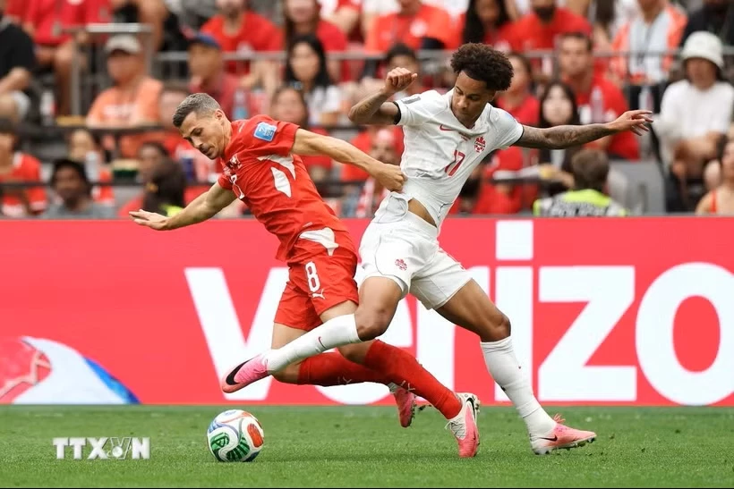 Thụy Sĩ (áo đỏ) và Canada cùng giành vé vào vòng knock-out World Cup 2026. (Ảnh: AFP/TTXVN)