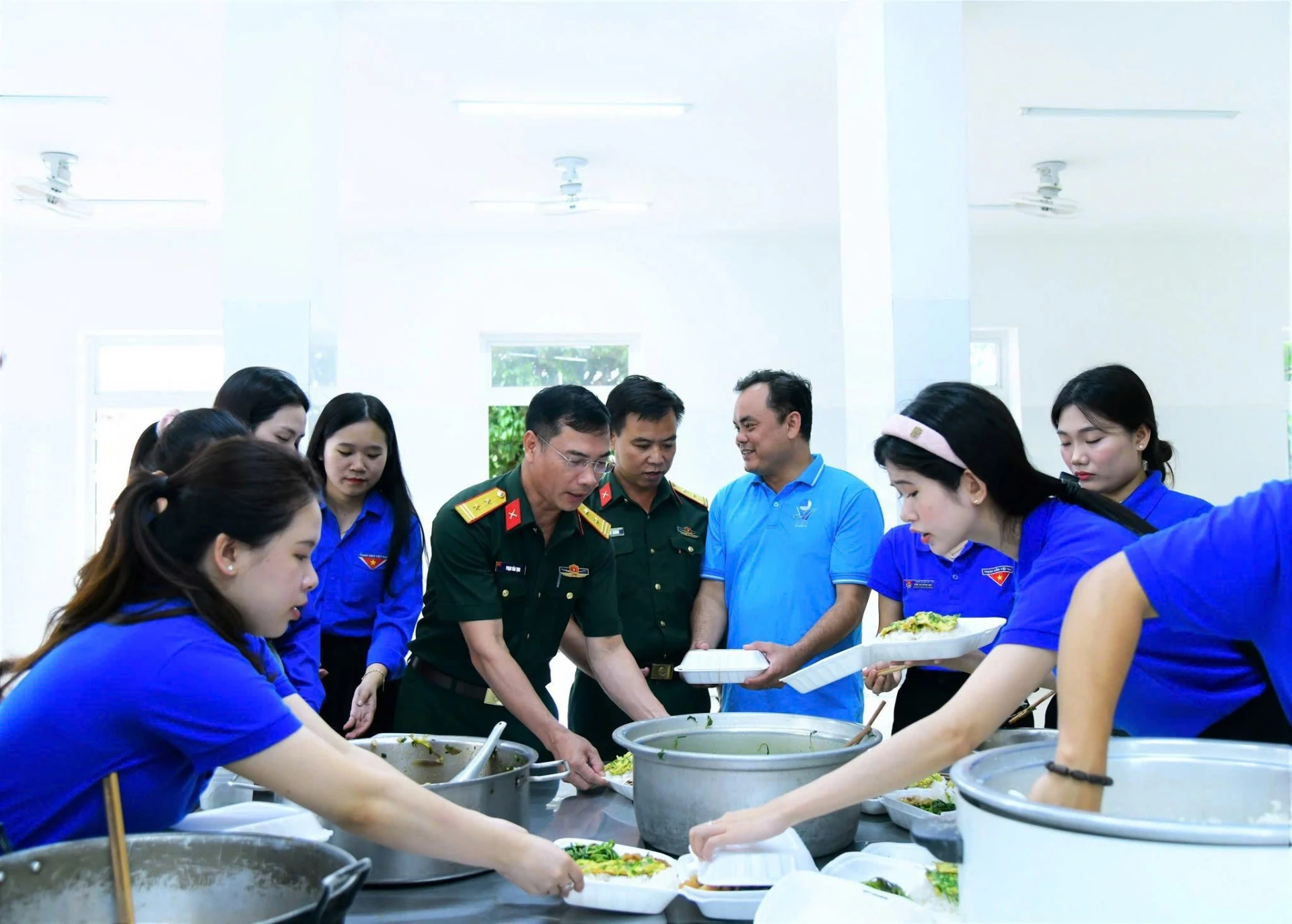 Các đơn vị phối hợp nấu cơm trưa miễn phí cho thí sinh dự thi tại điểm thi Trường THPT Hướng Phùng, xã Hướng Phùng - Ảnh: NVCC