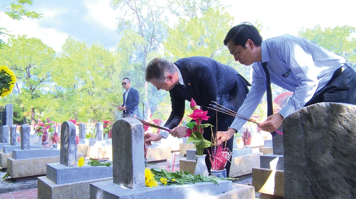 Đại sứ Mỹ Daniel Kritenbrink và Phó Chủ tịch UBND tỉnh Quảng Trị (cũ) Hoàng Nam thắp hương lên các phần mộ liệt sĩ - Ảnh: L.H