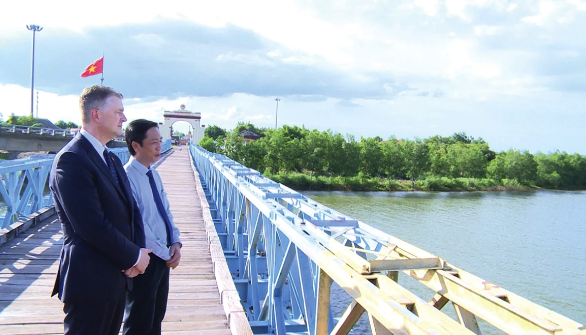 Đại sứ Mỹ Daniel Kritenbrink và Phó Chủ tịch UBND tỉnh Quảng Trị (cũ) Hoàng Nam trò chuyện trên cầu Hiền Lương - Ảnh: L.H