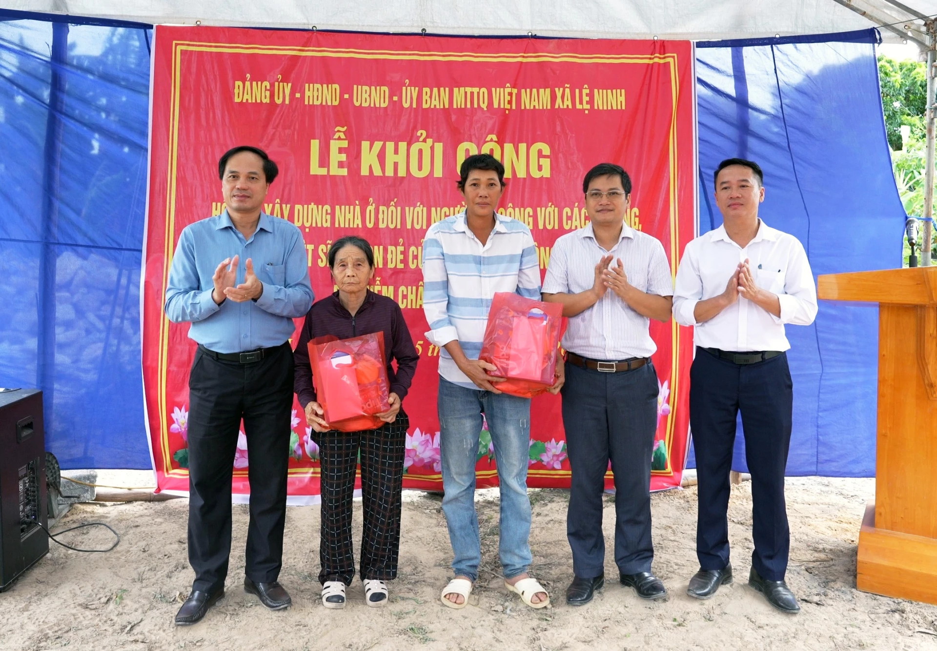 Đại diện lãnh đạo xã Lệ Ninh tặng quà cho các gia đình được hỗ trợ xây dựng nhà ở - Ảnh: L.C
