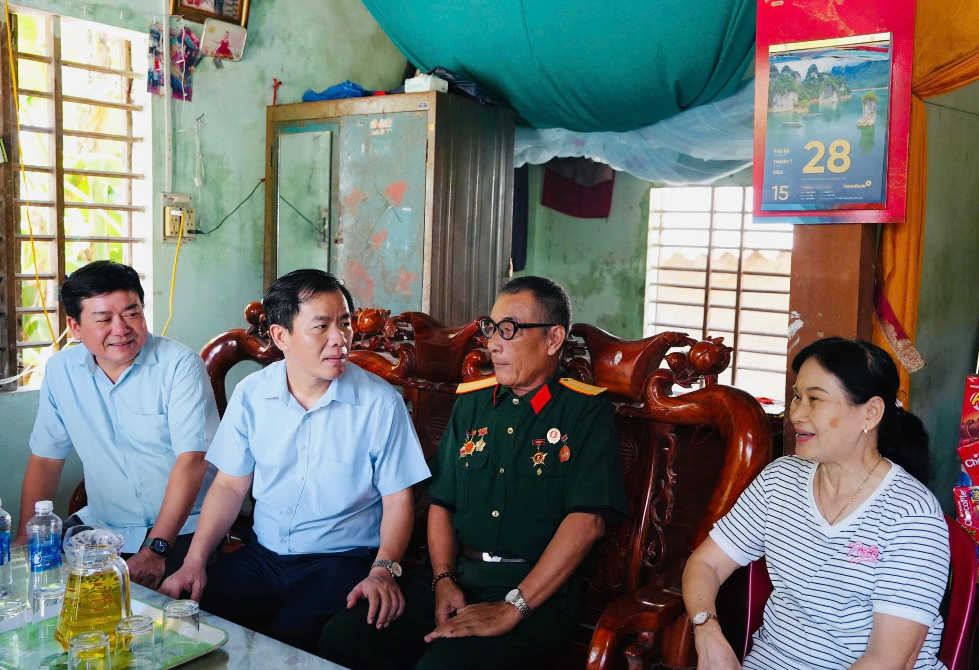 Đồng chí Bí thư Tỉnh ủy Nguyễn Văn Phương cùng đoàn công tác trò chuyện với thương binh Lê Văn Chung - Ảnh: Mỹ Nhị