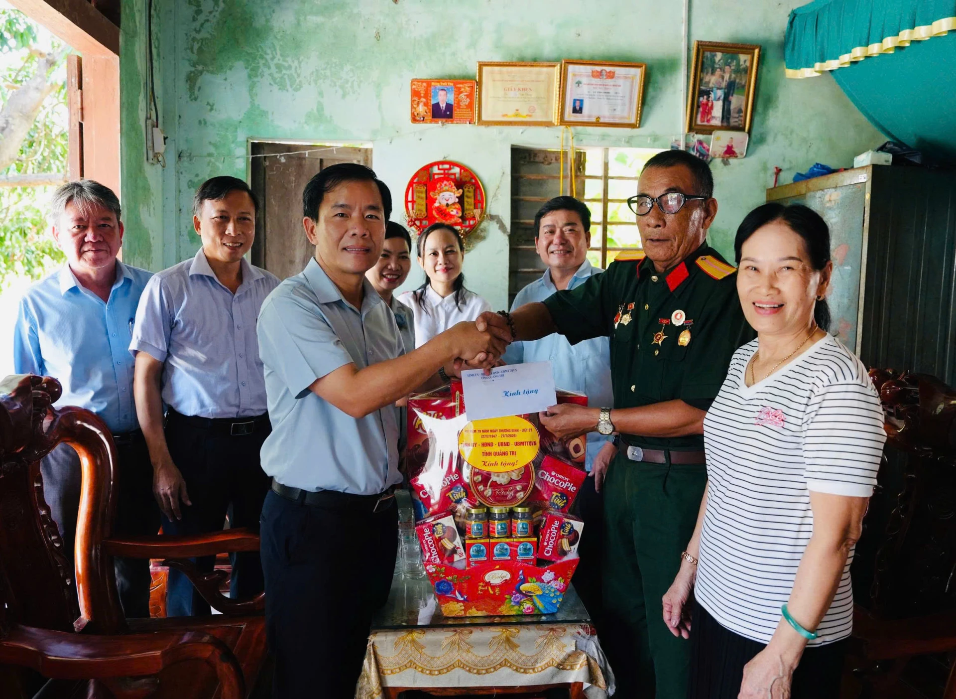 Đồng chí Nguyễn Văn Phương, Uỷ viên Ban Chấp hành Trung ương Đảng, Bí thư Tỉnh ủy trao quà và ân cần thăm hỏi, động viên thương binh Lê Văn Chung - Ảnh: Mỹ Nhị 