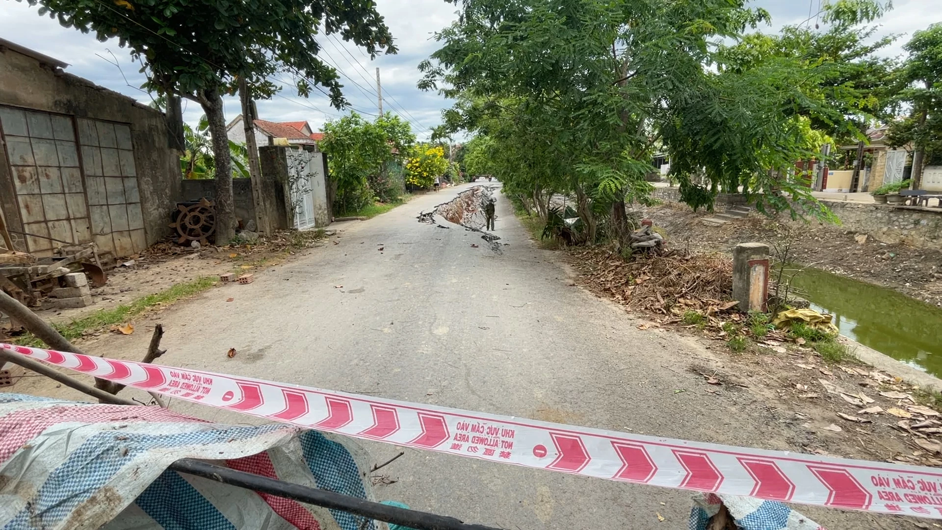 Lực lượng chức năng tiến hành căng dây cảnh báo an toàn từ xa ở hai đầu đoạn đường - Ảnh: N.M.P