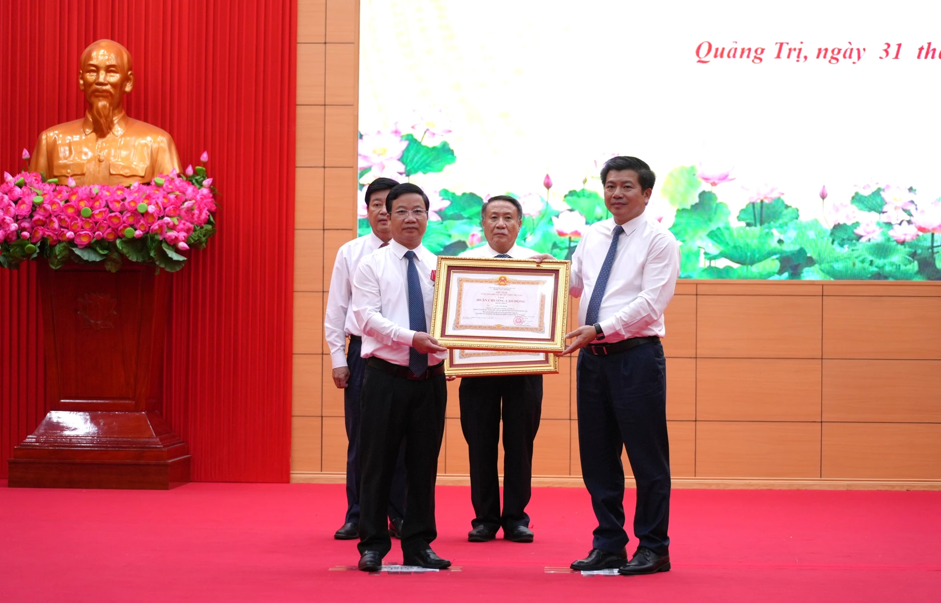 Đồng chí Trần Vũ Khiêm, Phó Bí thư Thường trực Tỉnh ủy trao Huân chương Lao động hạng Nhất của Chủ tịch nước cho đồng chí Cao Văn Định, nguyên Trưởng Ban Tuyên giáo Tỉnh ủy Quảng Bình (cũ) - Ảnh: T.Đ