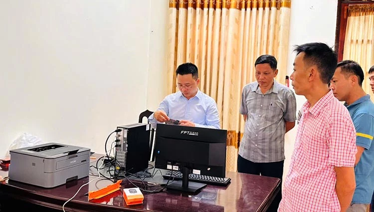 Cán bộ xã Minh Hóa lắp đặt, hướng dẫn cán bộ thôn sử dụng các thiết bị - Ảnh: C.T