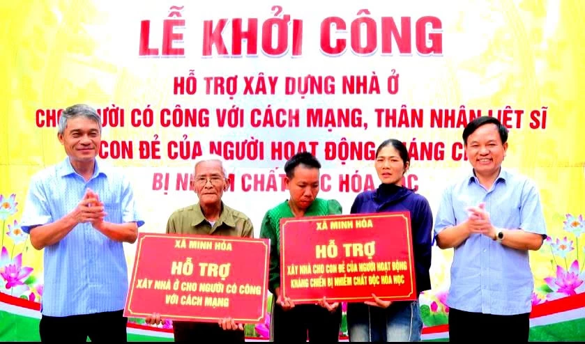 Lãnh đạo xã Minh Hóa trao biển tượng trưng khởi công xây dựng nhà ở cho 2 gia đình - Ảnh: C.T