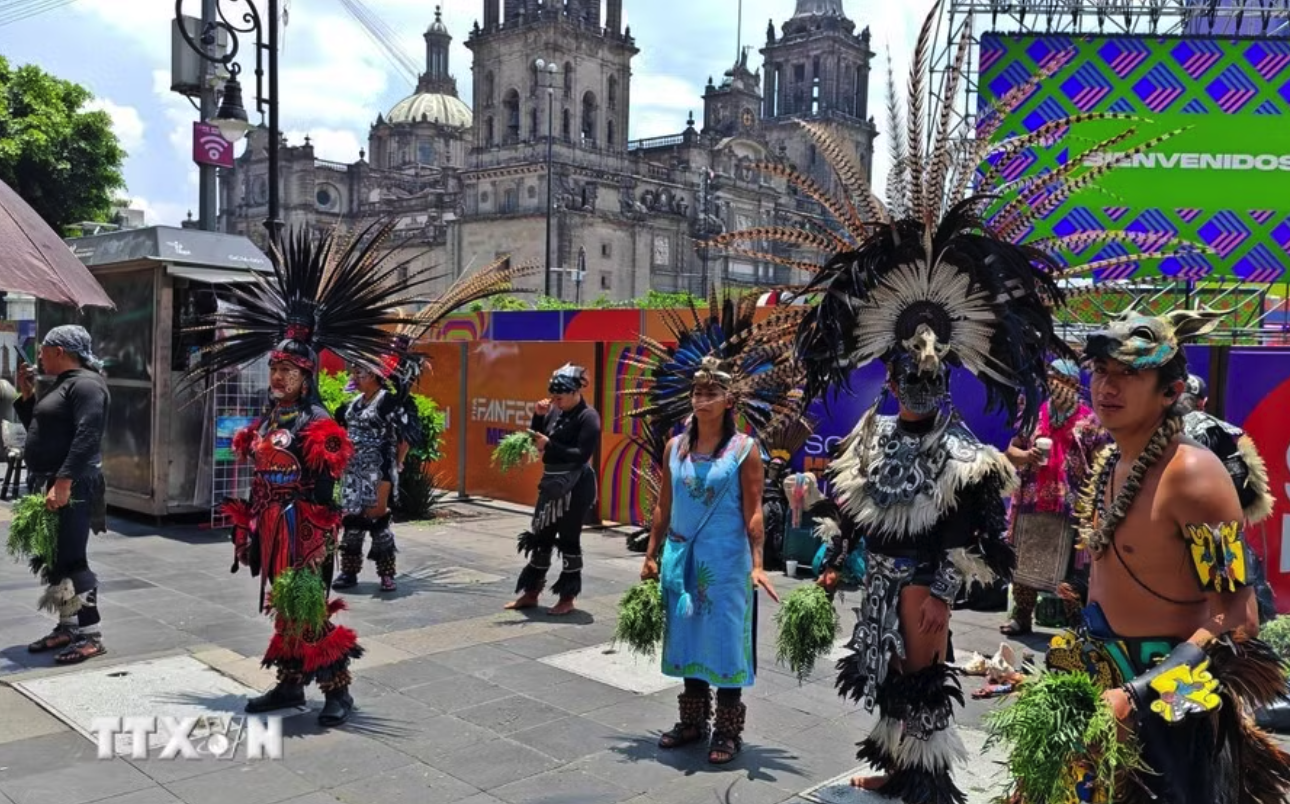 Các nghệ nhân trong trang phục truyền thống thực hiện nghi lễ thanh tẩy giữa trung tâm thủ đô Mexico City. (Ảnh: Phương Lan/TTXVN)