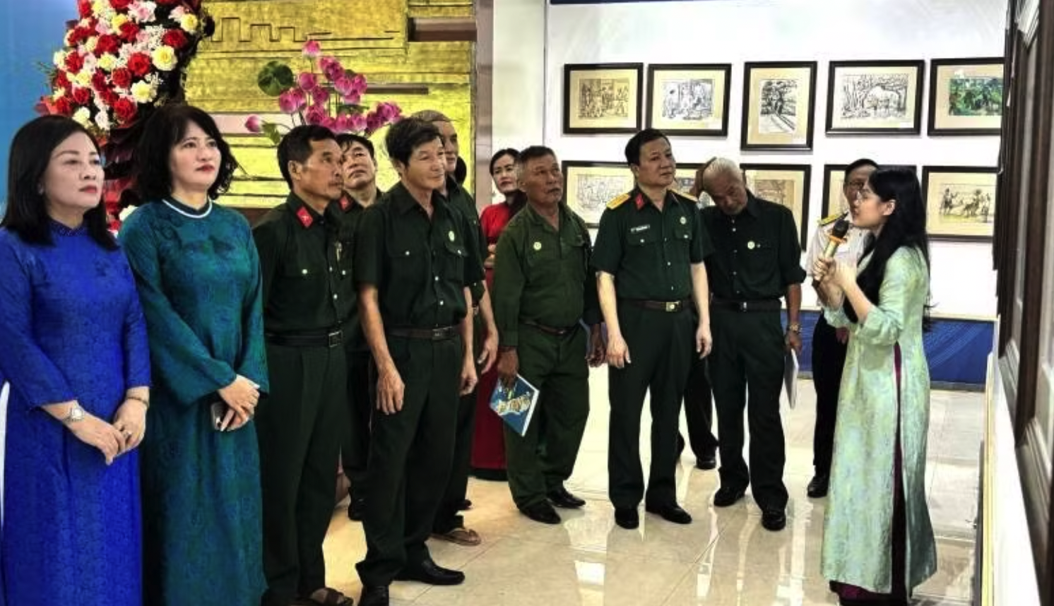 Các đại biểu và cựu chiến binh xem triển lãm tranh ký hoạ.