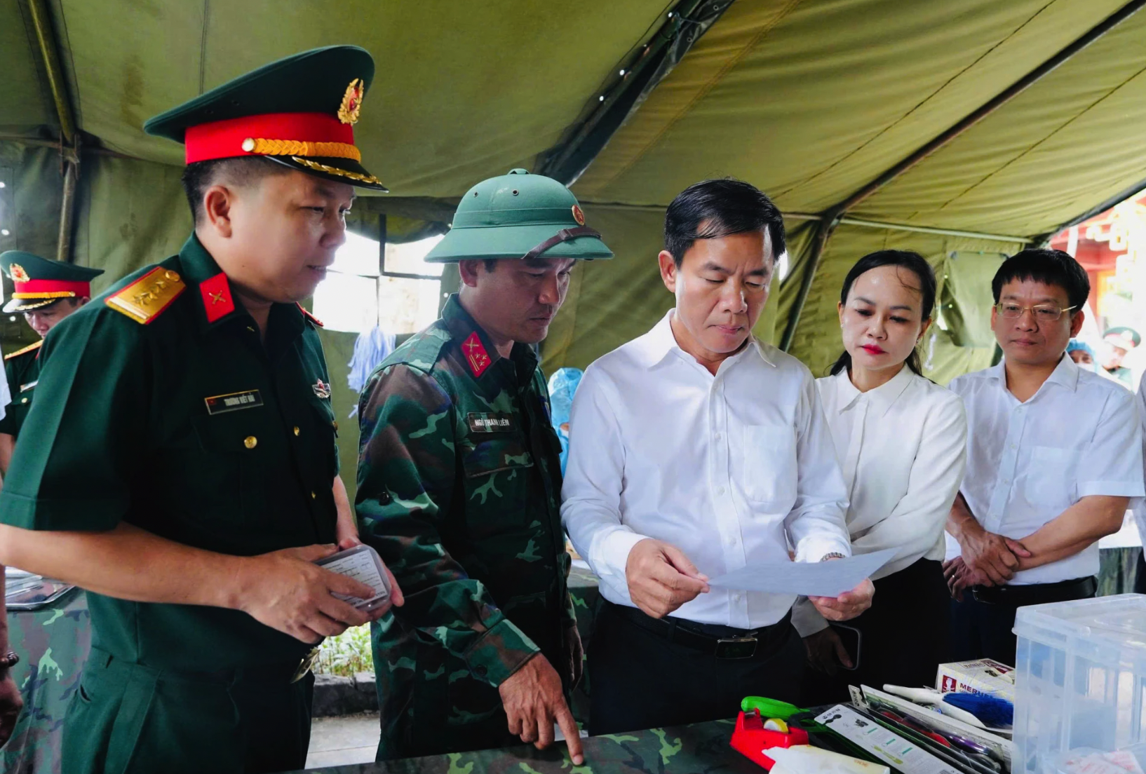 Đồng chí đại tá Trương Viết Hải, Chính ủy Bộ Chỉ huy Quân sự tỉnh báo cáo với đồng chí Nguyễn Văn Phương, Bí thư Tỉnh ủy và đoàn công tác về tiến độ, quy trình chuyên môn trong công tác quy tập hài cốt liệt sĩ - Ảnh: Mỹ Nhị