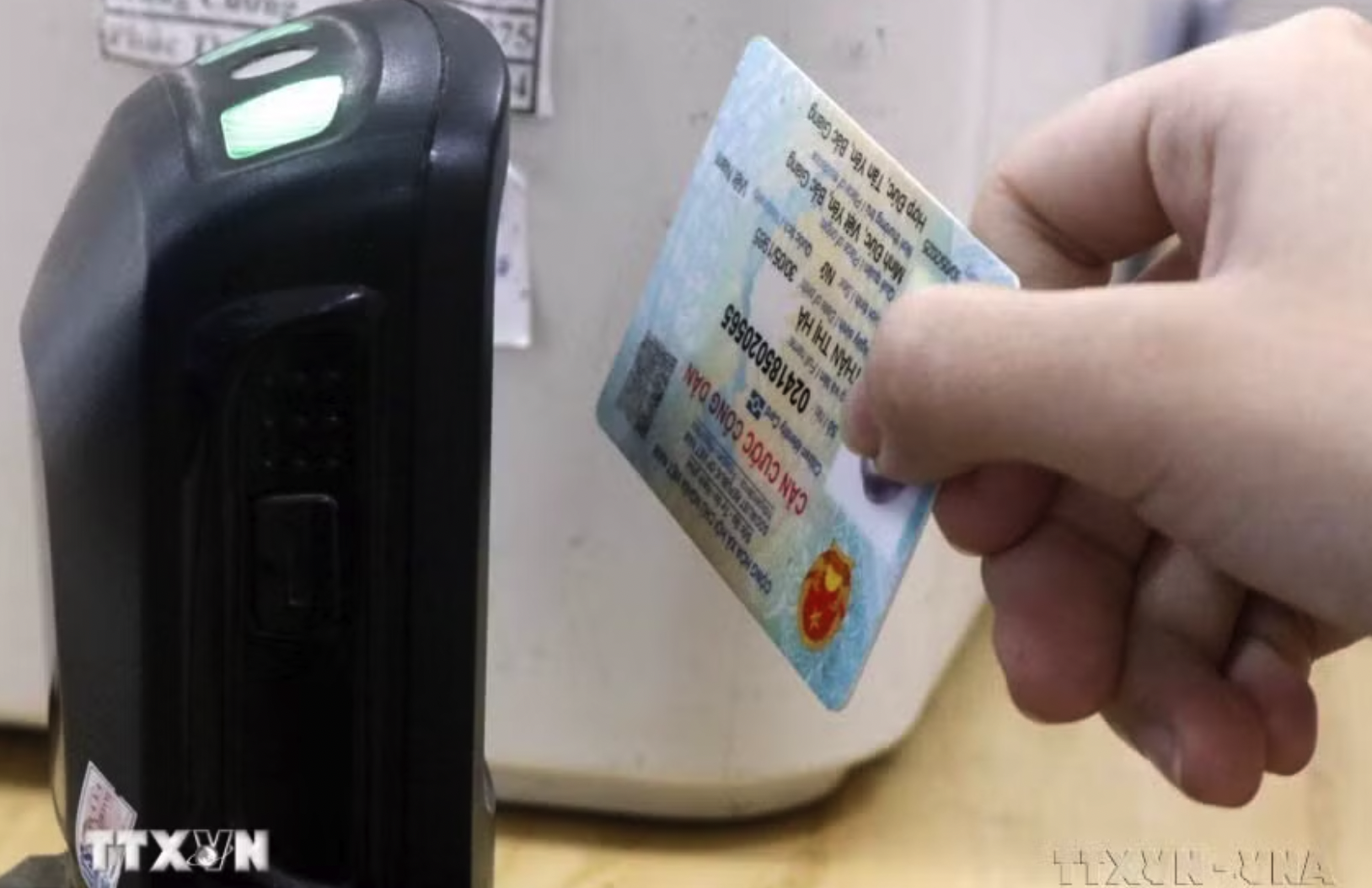Dùng máy quét QR code trên căn cước gắn chip để tra cứu thông tin người bệnh. (Ảnh: Đồng Thúy/TTXVN)