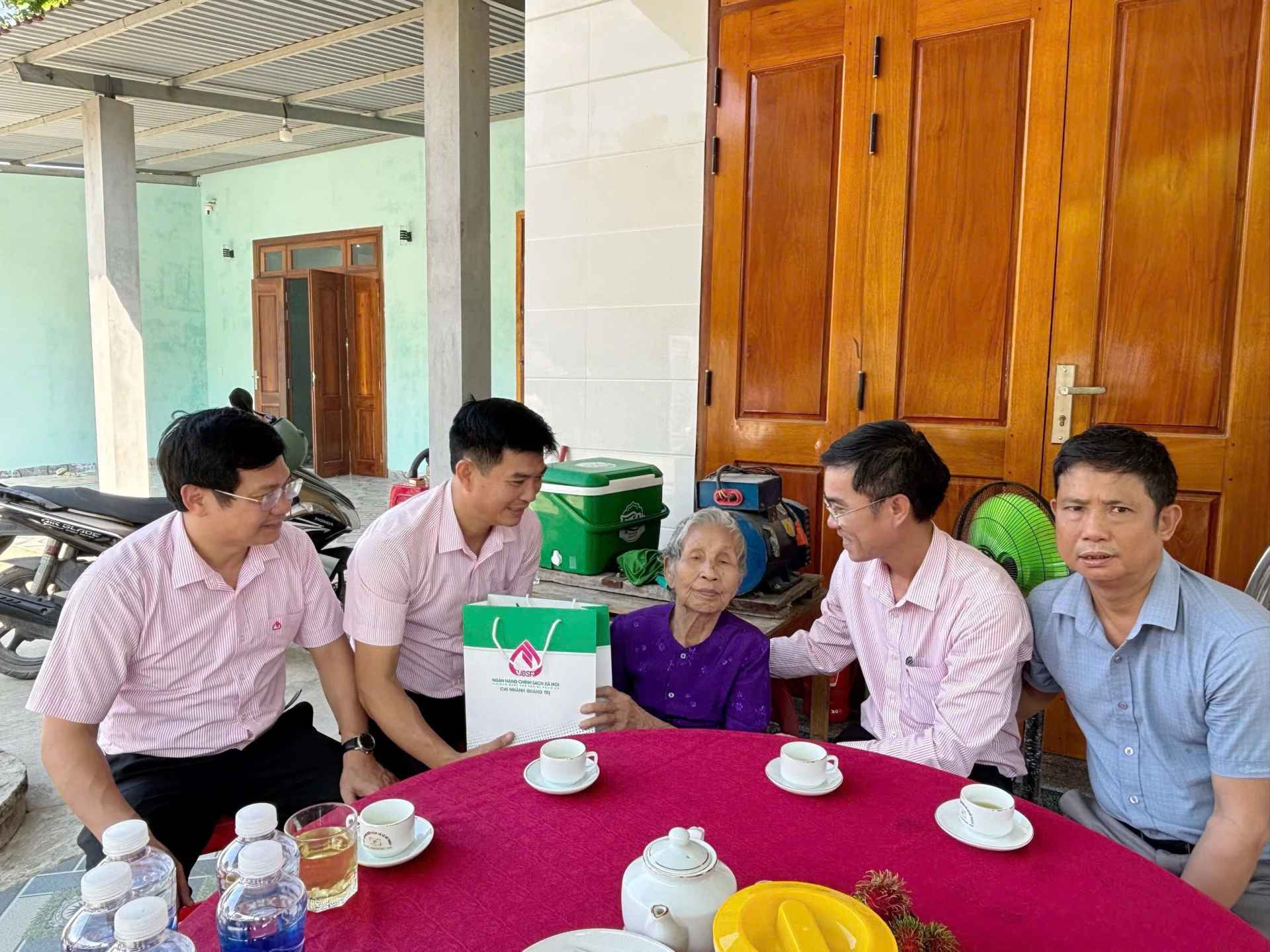 Đại diện lãnh đạo Chi nhánh Ngân hàng CSXH thăm, tặng quà Mẹ Việt Nam anh hùng Đỗ Thị Điểm, ở thôn Cổ Giang, xã Bố Trạch -Ảnh: M.L