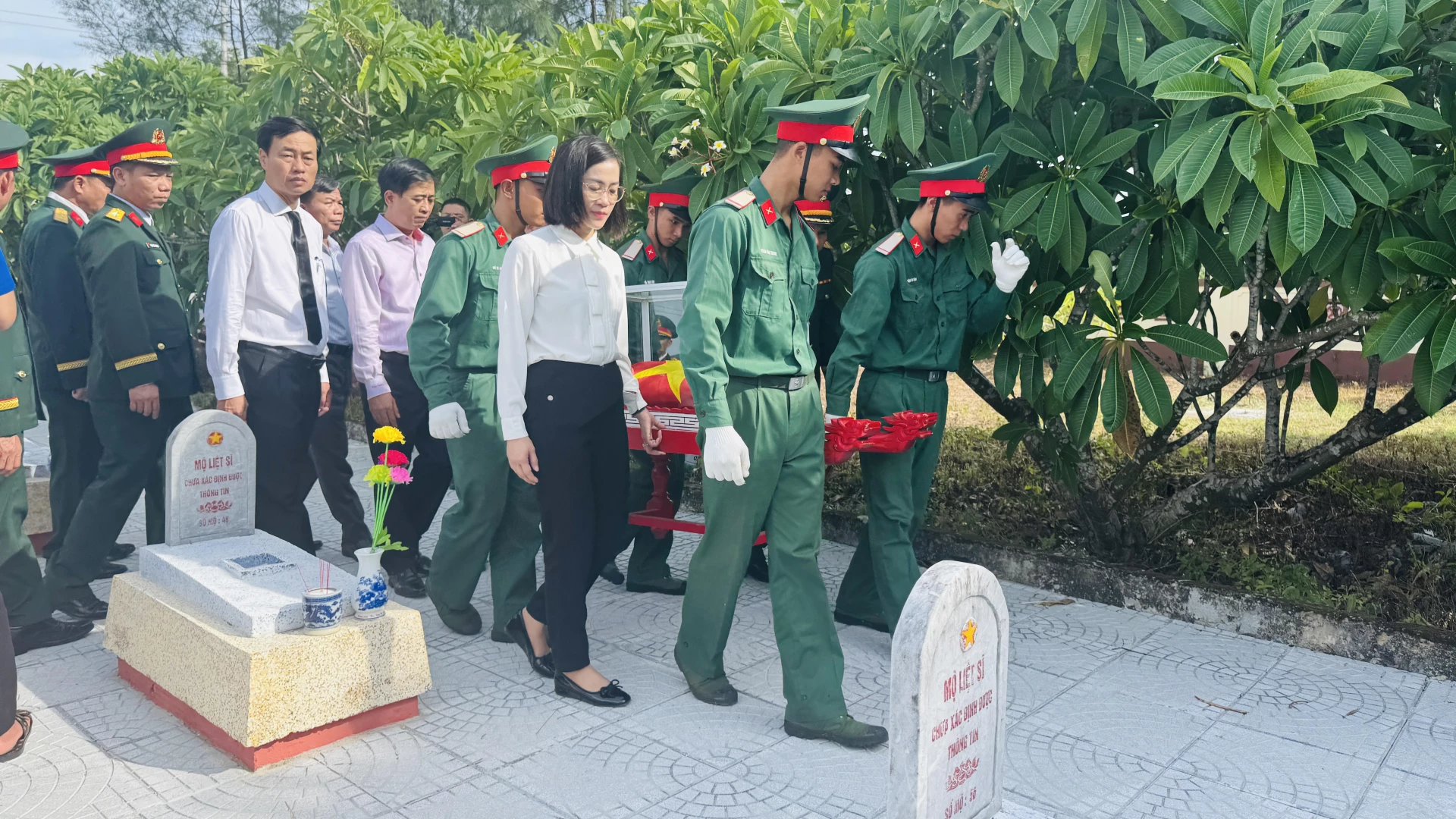 Đại diện lãnh đạo Sở Nội vụ và xã Hiếu Giang đưa hài cốt liệt sỹ về nơi an táng - Ảnh: MT