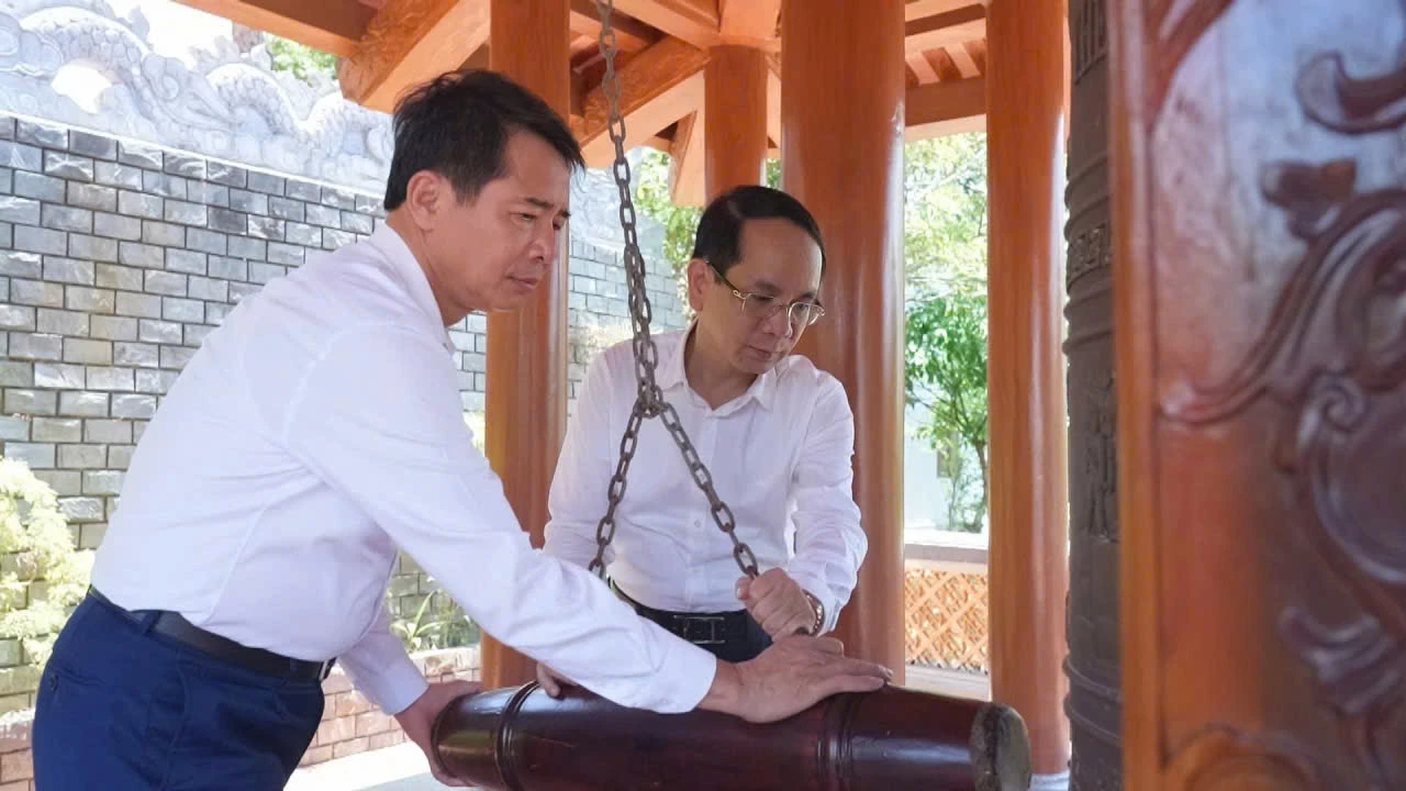 Đồng chí Bí thư Đảng ủy và đồng chí Chủ tịch UBND phường Đồng Hới thỉnh chuông tại đền tưởng niệm Liệt sĩ Trường Sơn bến phà Long Đại - Ảnh: P.V
