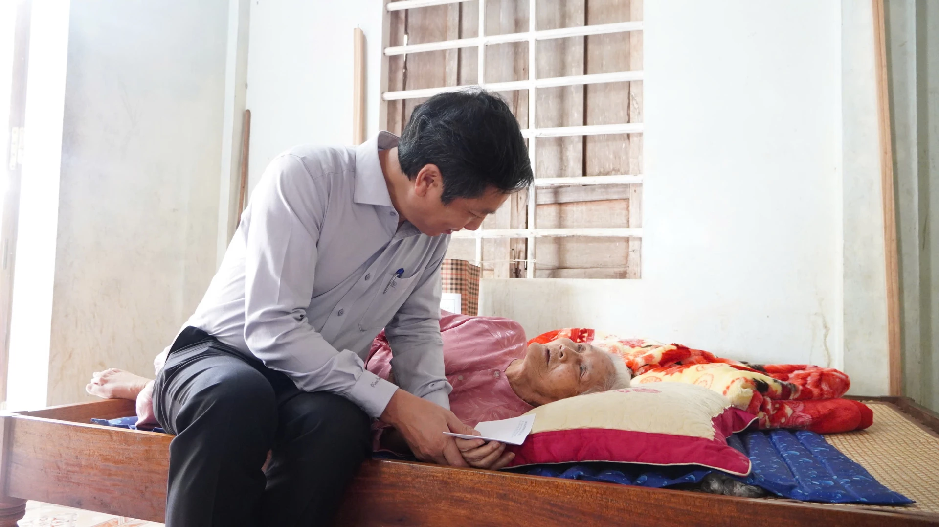 Đồng chí Hoàng Nam, Phó Chủ tịch Thường trực UBND tỉnh hỏi thăm sức khỏe bà Tạ Thị Thả ở xã Cam Lộ - Ảnh: MT