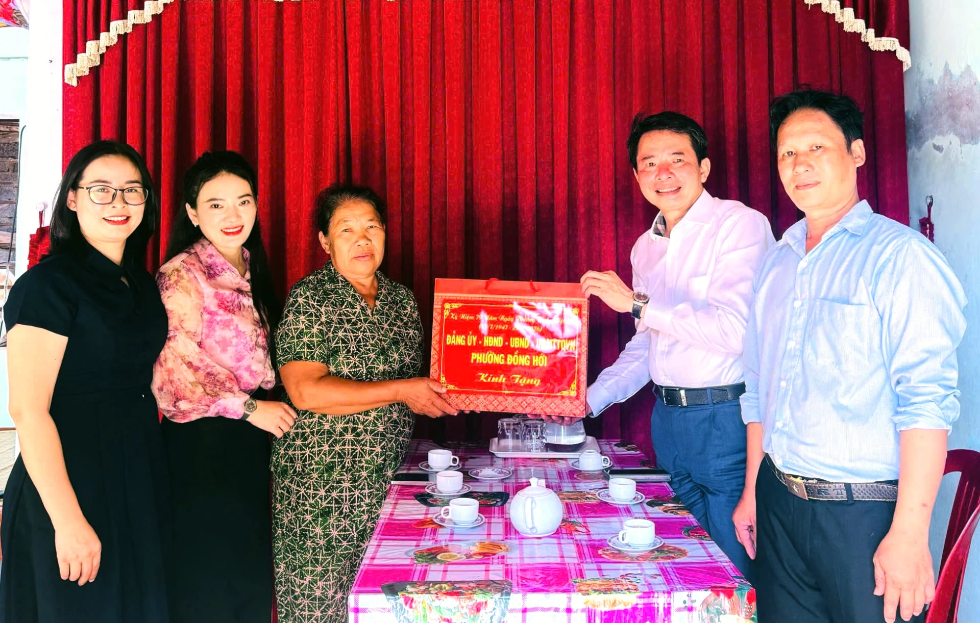 Đồng chí Chủ tịch UBND phường Đồng Hới Hoàng Ngọc Đan và các thành viên đoàn công tác trao quà bà Trần Thị Tuyến, thân nhân liệt sĩ, ở TDP Phú Hải.
