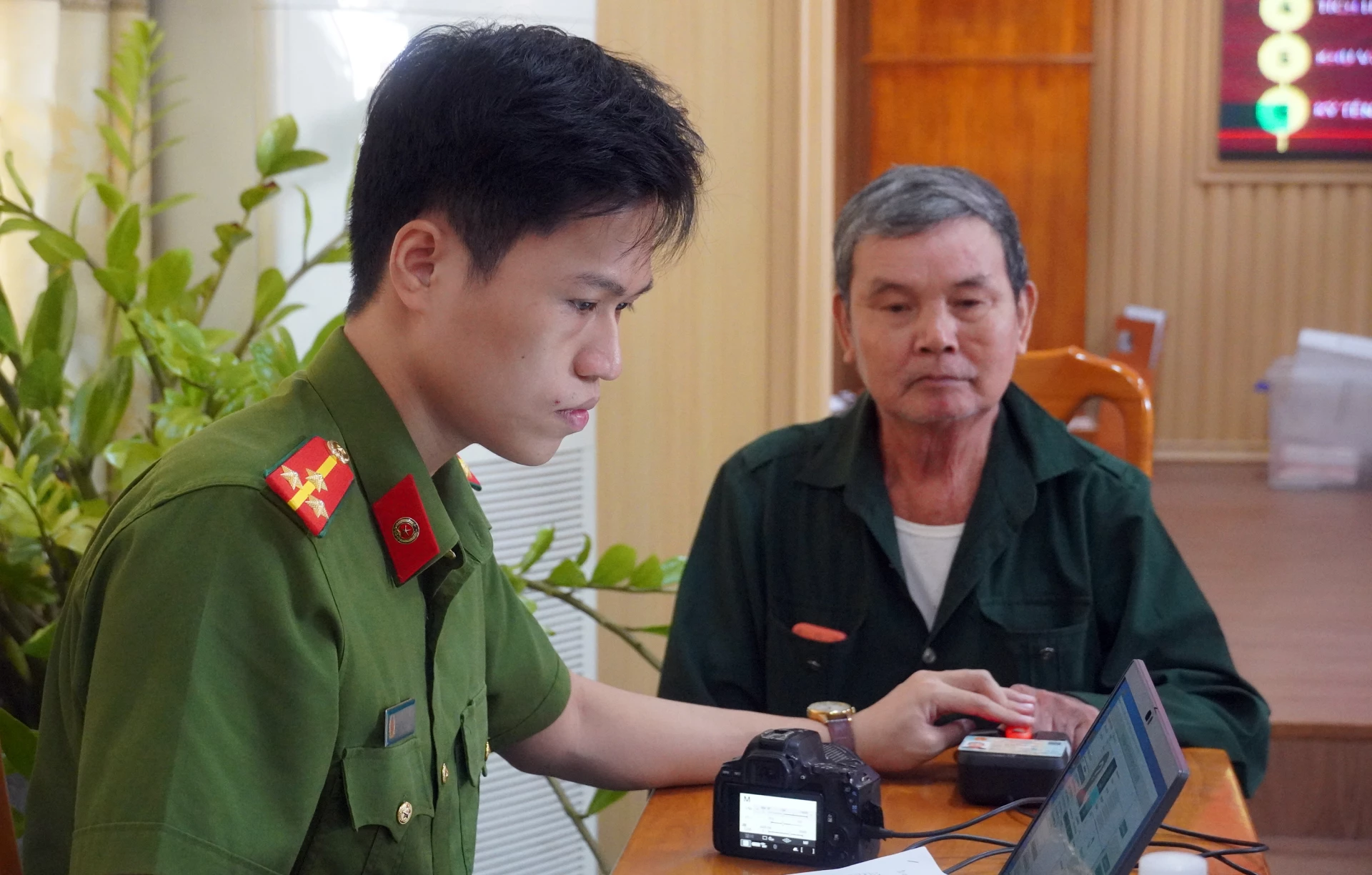 Cán bộ Công an hỗ trợ, hướng dẫn thân nhân liệt sĩ thực hiện quy trình lấy mẫu AND - Ảnh: N.M
