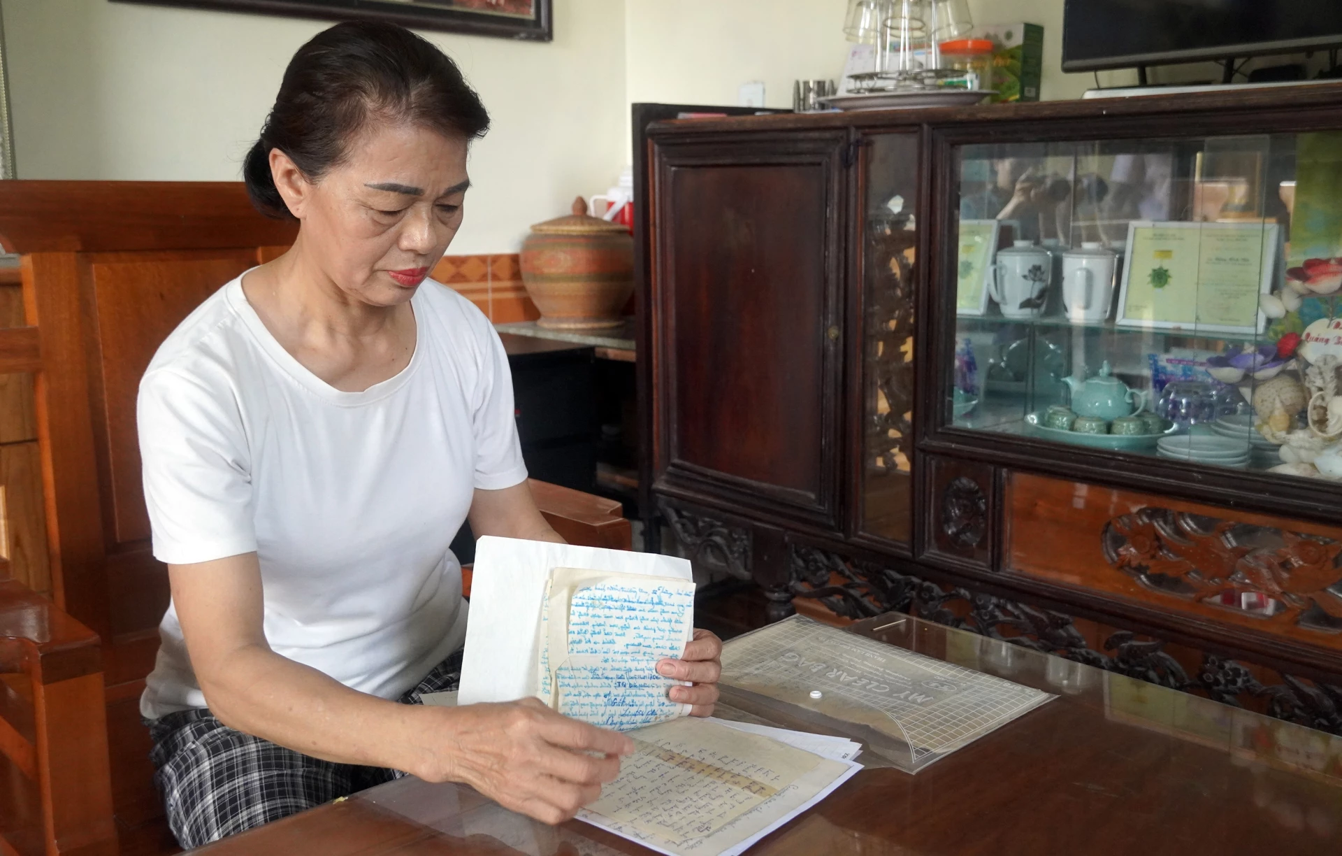Bà Lê Thị Lý (phường Đồng Hới) và những kỷ vật về người cha thân yêu chưa từng gặp mặt - Ảnh: N.M