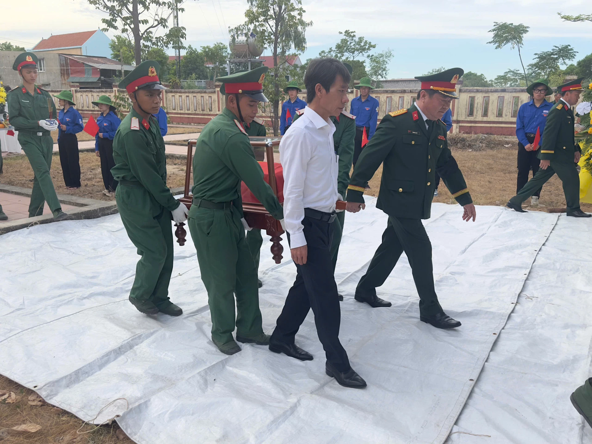 Các đại biểu đưa hài cốt liệt sĩ về nơi an táng - Ảnh: Thùy Trang