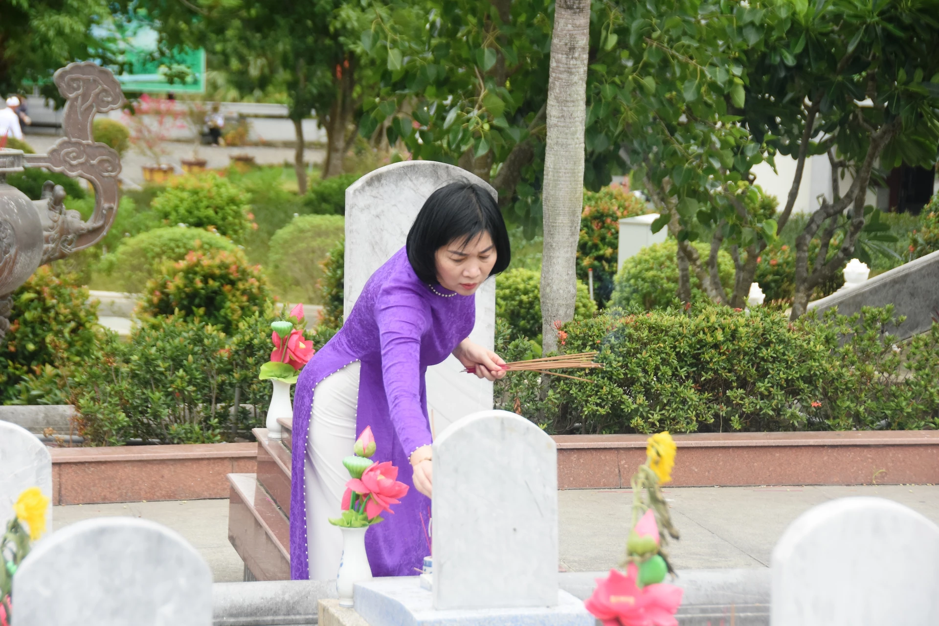 Đồng chí Phùng Thị Hồng Hà, Phó Bí thư Thành ủy, Chủ tịch HĐND thành phố Hà Nội thắp nhang lên phần mộ liệt sĩ - Ảnh: ĐV