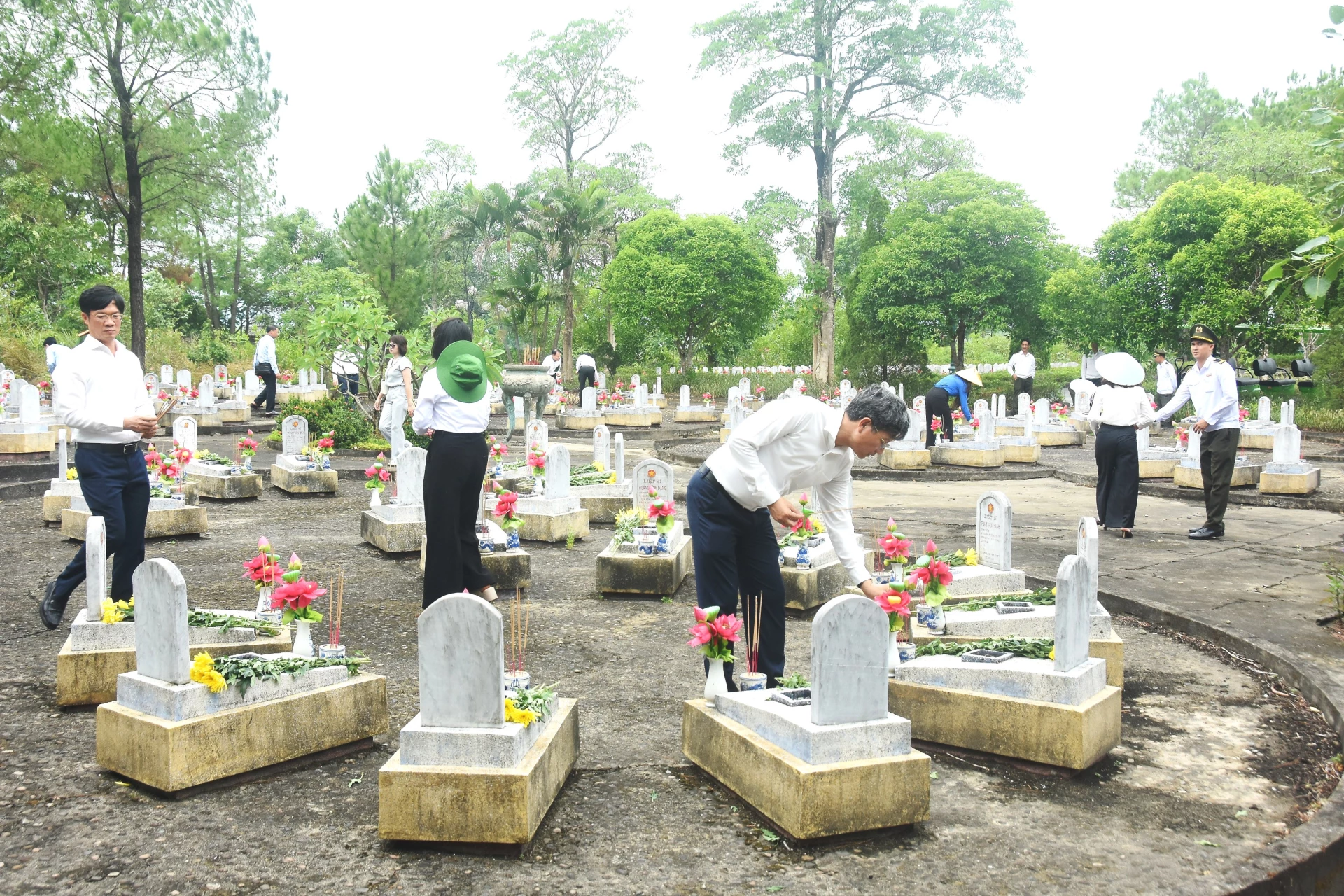 Các thành viên đoàn công tác TP. Hải Phòng thắp nhang lên các phần mộ liệt sĩ ở Nghĩa trang Liệt sĩ quốc gia Đường 9 - Ảnh: Đ.V