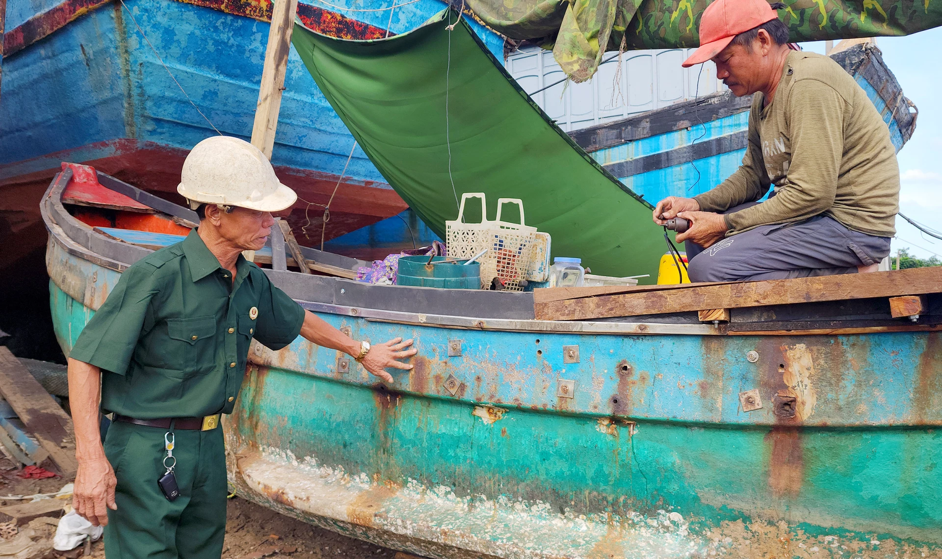 Cựu chiến binh Cao Xuân Đố trực tiếp chỉ đạo công việc sửa chữa tàu thuyền - Ảnh: T.L