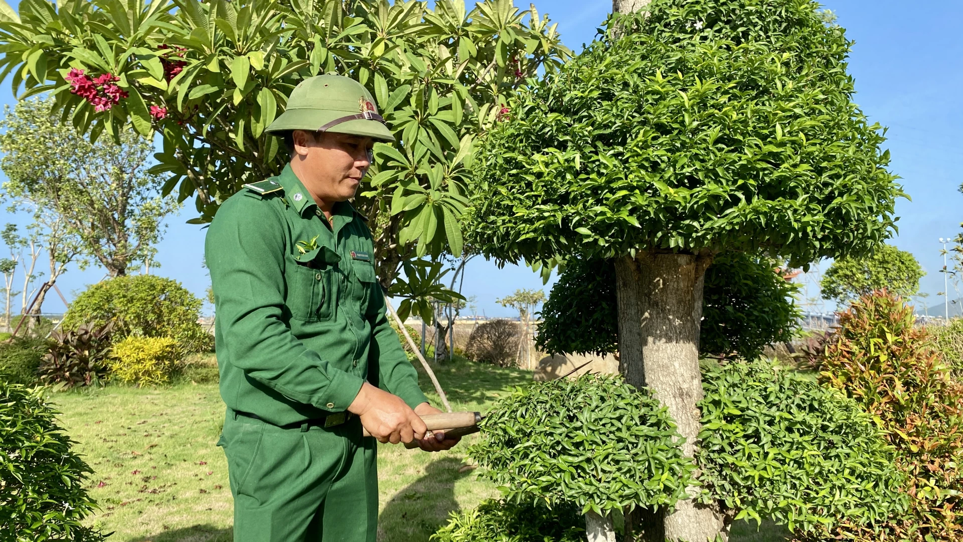 Anh Phan Xuân Nam chăm sóc vườn cây tại Khu di tích lịch sử quốc gia đặc biệt Bến phà Gianh -Ảnh: H.N