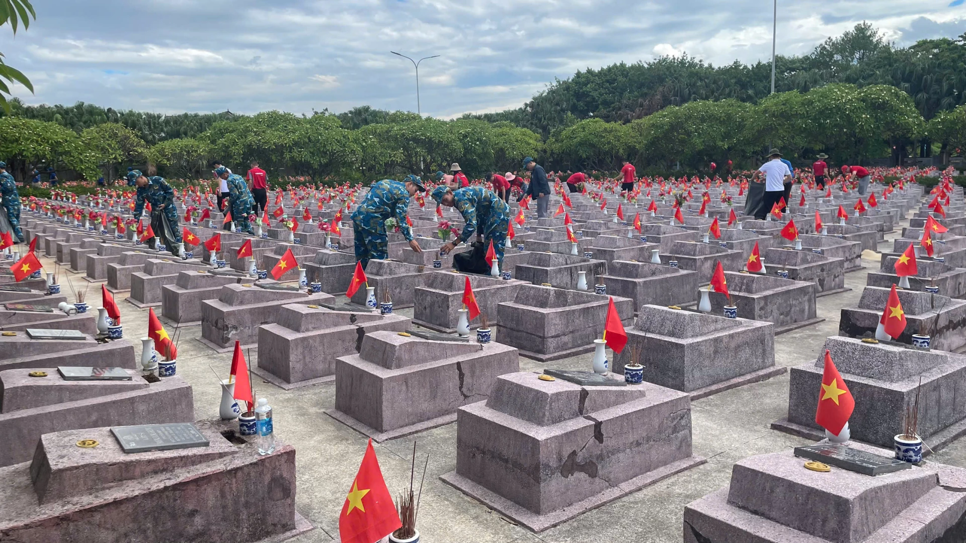 Các đoàn viên, thanh niên chăm sóc khuôn viên Nghĩa trang Ba Dốc - Ảnh: LT