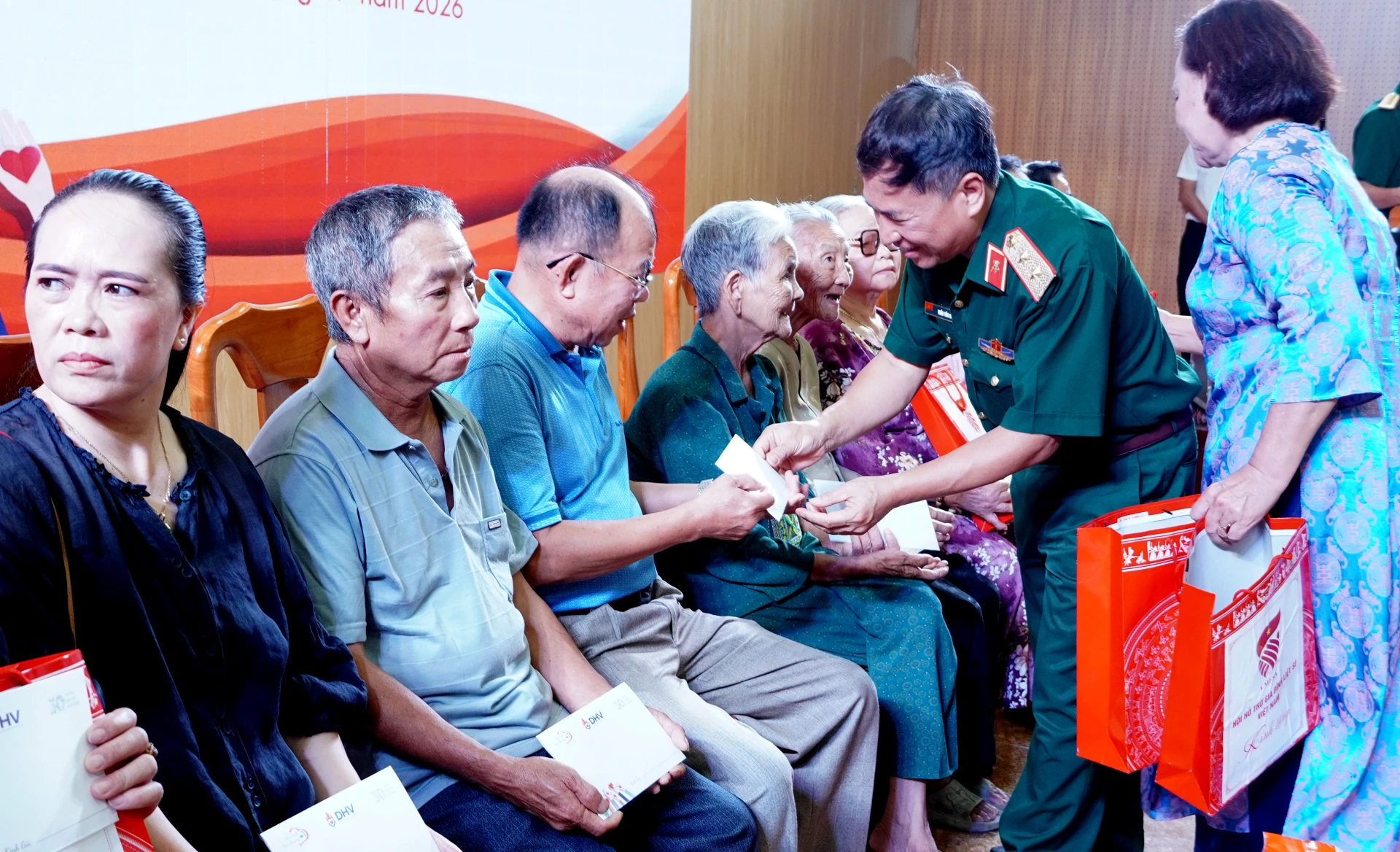 Trung tướng Trần Tấn Hùng, Phó Chủ tịch Hội Hỗ trợ gia đình liệt sĩ Việt Nam và đại diện các đơn vị, địa phương trao quà tặng các gia đình người có công - Ảnh: H.Tr.