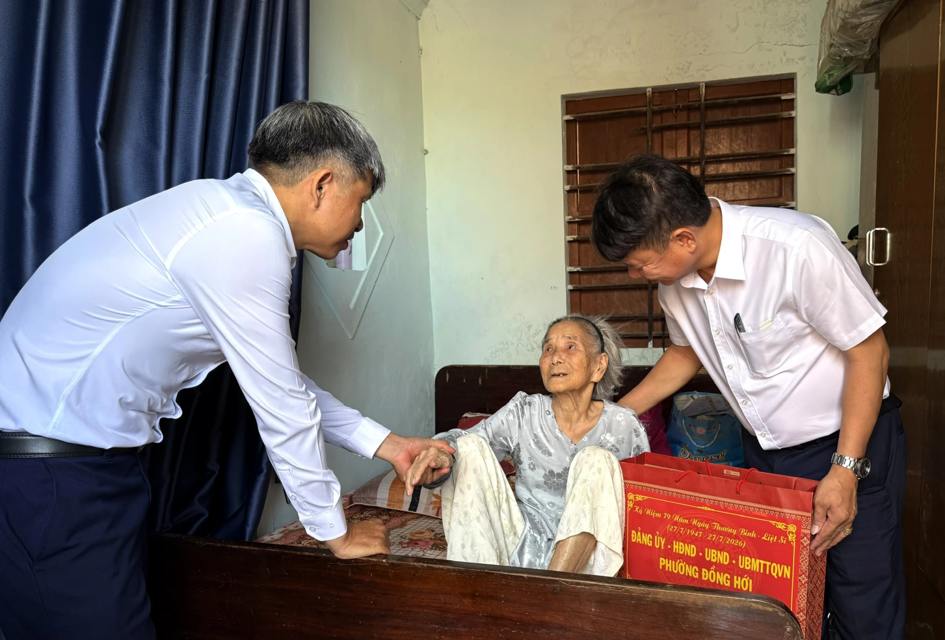 Chủ tịch Ủy ban MTTQ Việt Nam phường Đồng Hới Bùi Quang Vinh và thành viên đoàn công tác trao quà tặng quà bà Nguyễn Thị Hương, thân nhân liệt sĩ, ở TDP Bảo Ninh 3.