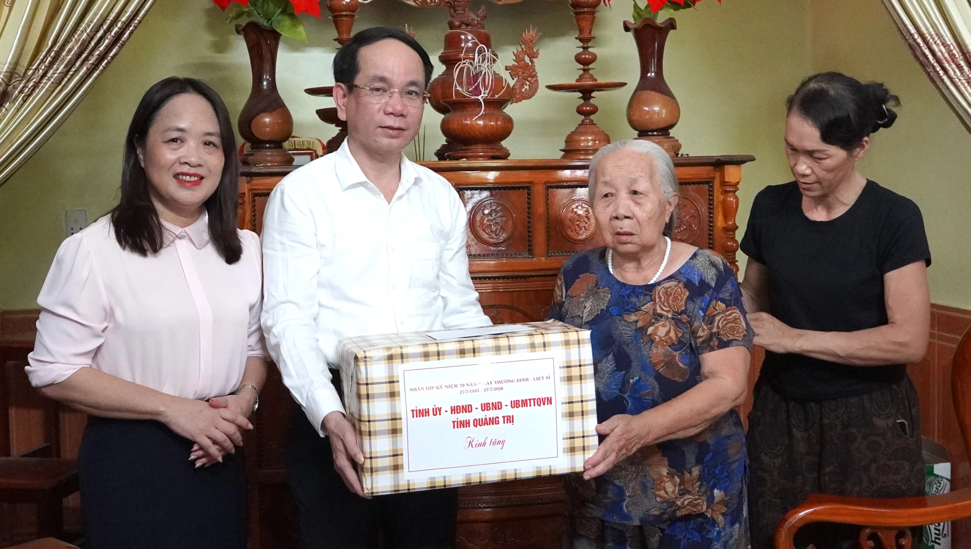 Bí thư Đảng ủy phường Đồng Hới Phan Mạnh Hùng và đại diện cấp ủy địa phương trao quà tặng bà Trần Thị Man (vợ liệt sĩ Lê Hồng Thuông, xã Nam Trạch) - Ảnh: H.Tr.