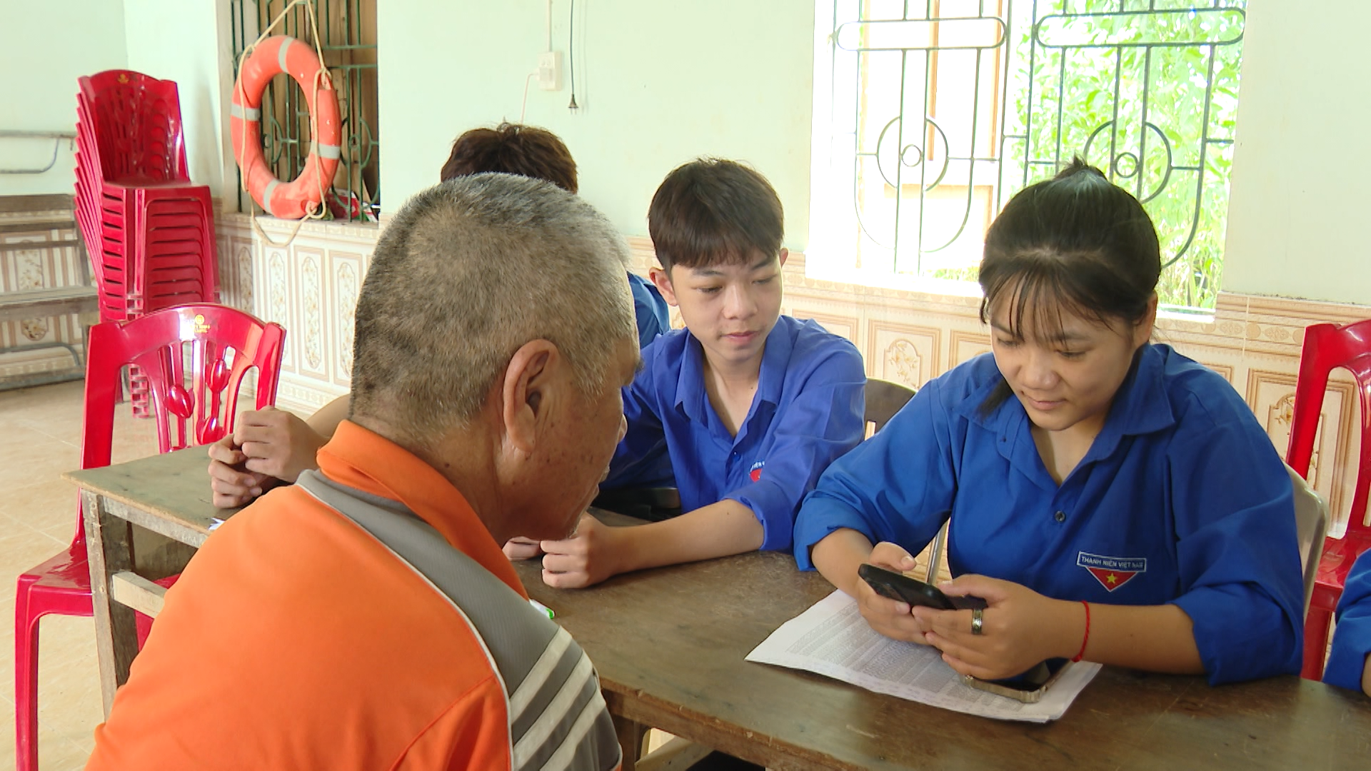 Ông Phạm Hữu Thùy, thôn Thượng Phong, xã Lệ Thủy được Tổ công nghệ số cộng đồng thôn hướng dẫn thực hiện các ứng dụng số trên điện thoại - Ảnh: N.D
