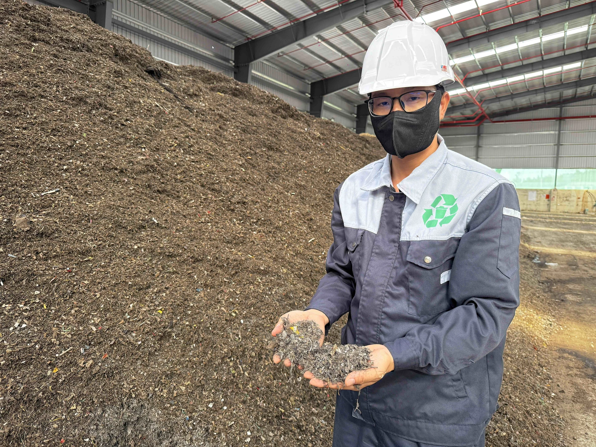 Sản phẩm mùn hữu cơ sau giai đoạn sơ chế, tiếp tục được ủ để sản xuất phân hữu cơ - Ảnh: Quang Ngọc.