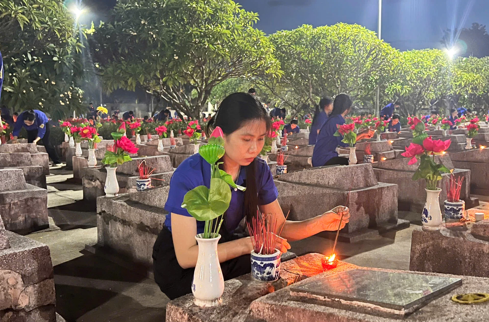 Các đoàn viên thanh niên thắp nến, dâng hương lên các phần mộ liệt sĩ - Ảnh: X.P

