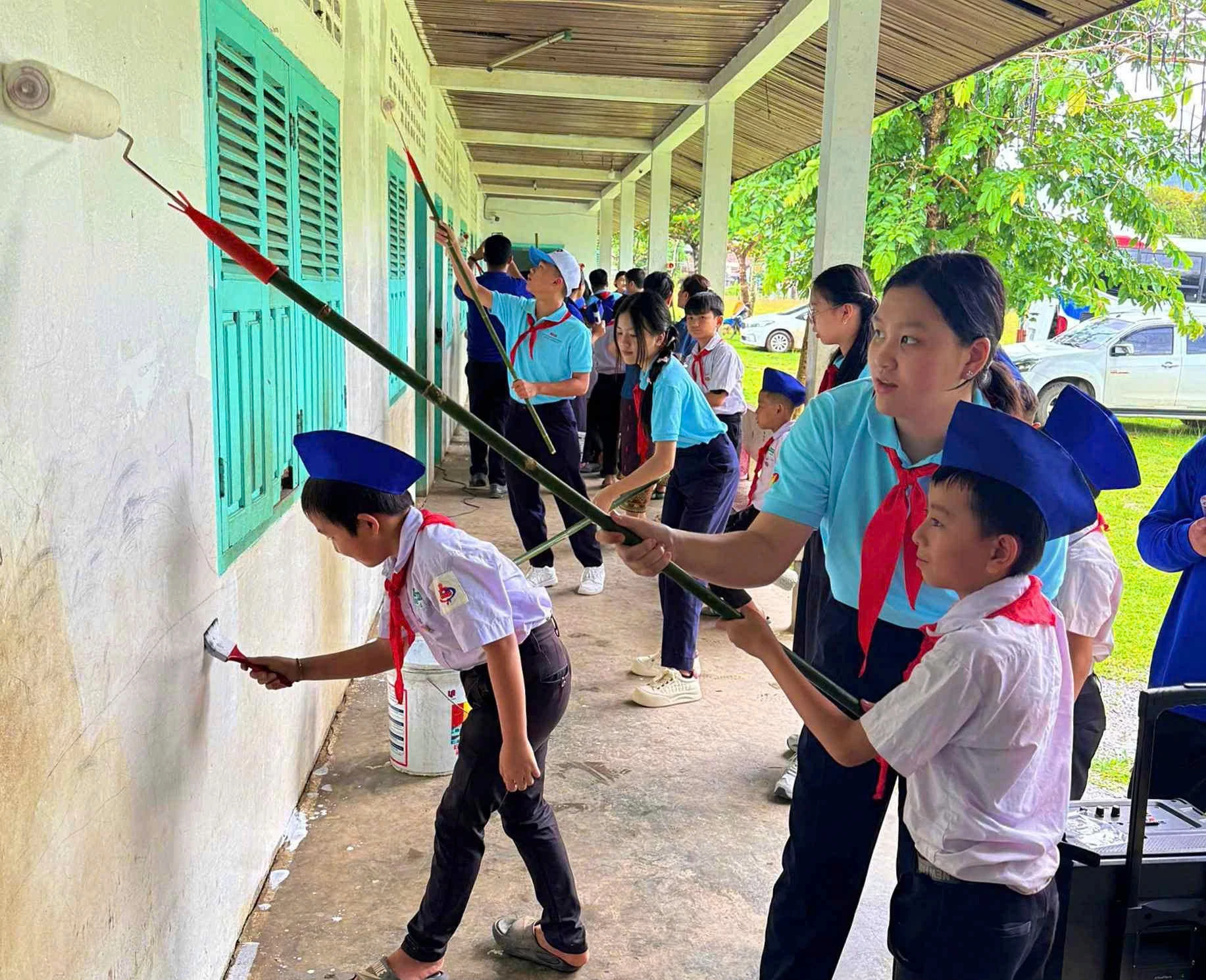 Các bạn nhỏ đến từ Việt Nam cùng thanh thiếu nhi Lào sơn tường ở một ngôi trường thuộc huyện Vang Vieng - Ảnh: NVCC