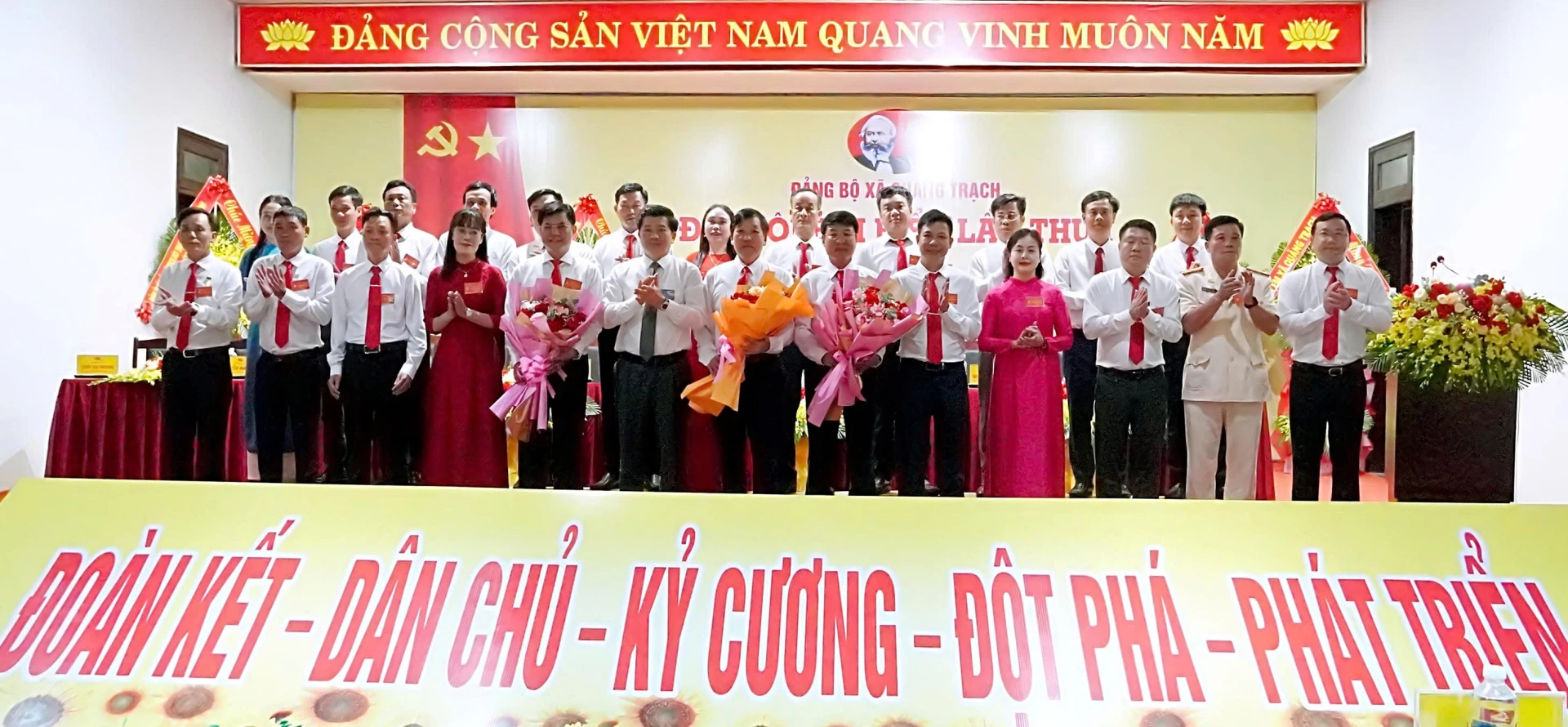 Trưởng Ban Tổ chức Tỉnh ủy Trần Vũ Khiêm tặng hoa chúc mừng Ban Chấp hành Đảng bộ xã Quảng Trạch, nhiệm kỳ 2025-2030. Ảnh: H.Tr.