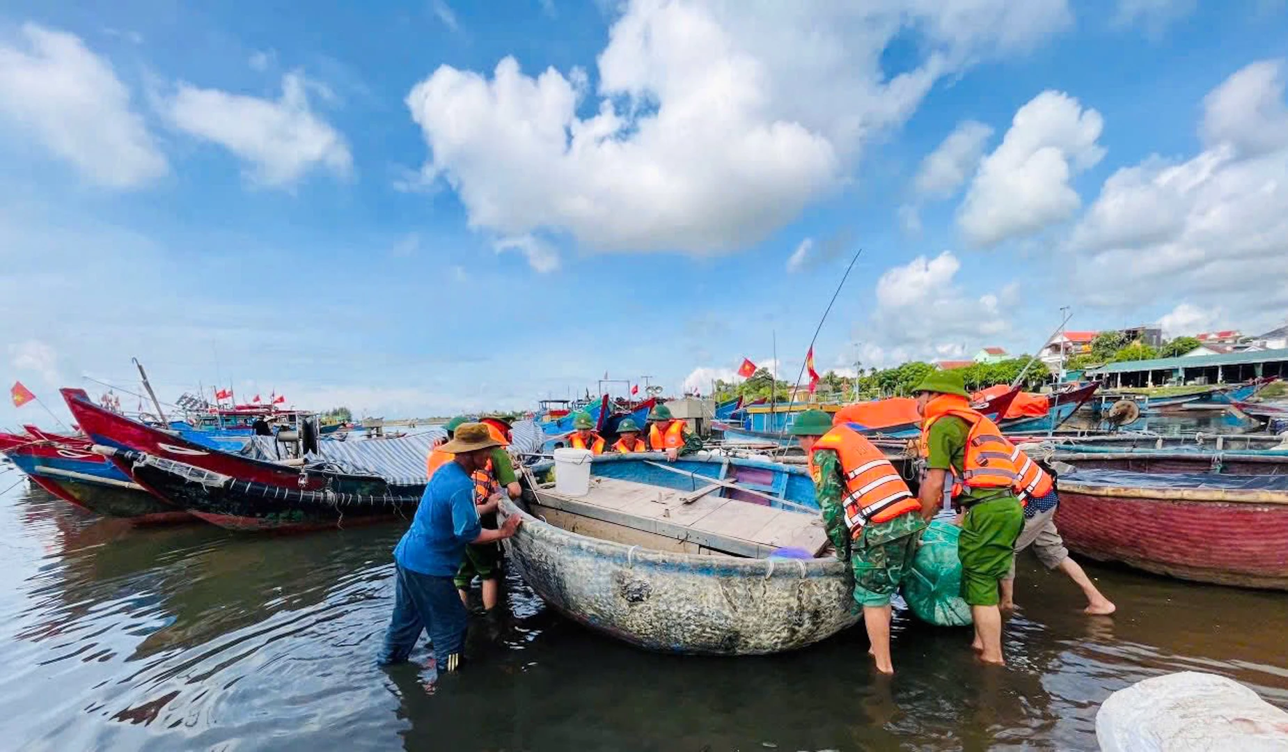 Lực lượng chức năng hỗ trợ ngư dân xã Cửa Tùng neo đậu tàu thuyền vào nơi an toàn
