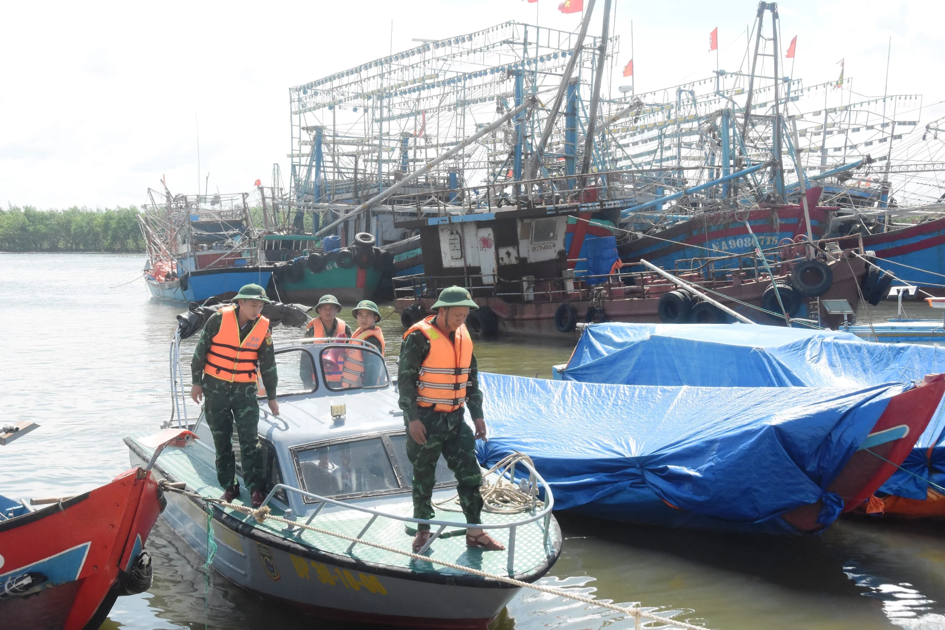Cán bộ, chiến sĩ Đồn Biên phòng Triệu Vân kêu gọi ngư dân neo đậu tàu thuyền an toàn trước bão số 5 - Ảnh: ĐV