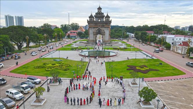 Cộng đồng người Việt cùng nhau xếp hình số 80 để chào mừng 80 năm Quốc khánh Việt Nam. Ảnh: Đỗ Bá Thành/PV TTXVN tại Lào
