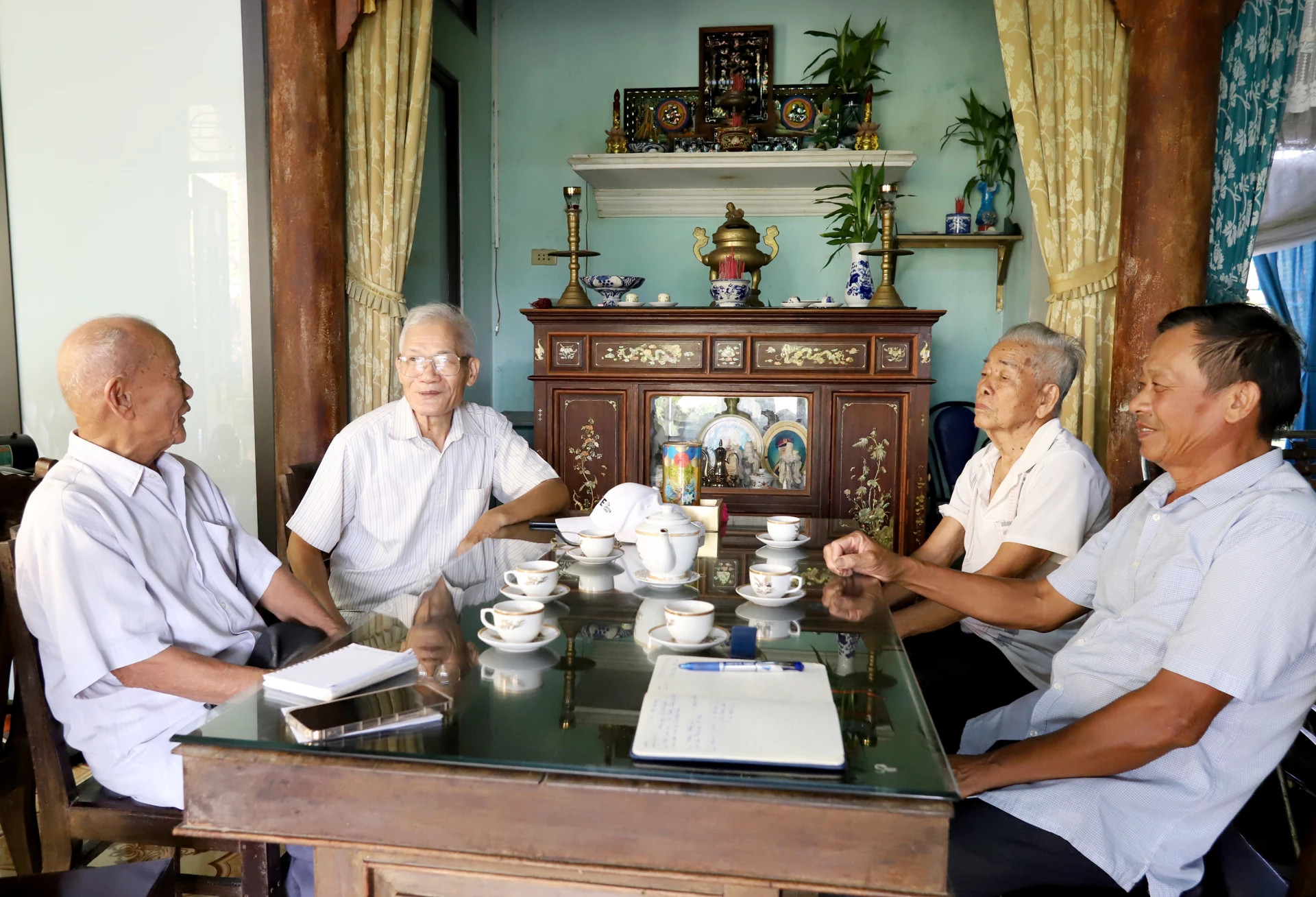 Ông Phạm Phước, nguyên Chủ tịch UBND tỉnh Quảng Bình trò chuyện với các nhân chứng lịch sử từng nuôi dấu cán bộ Việt Minh ở thôn Thượng (Võ Xá)-Ảnh: T.Long.