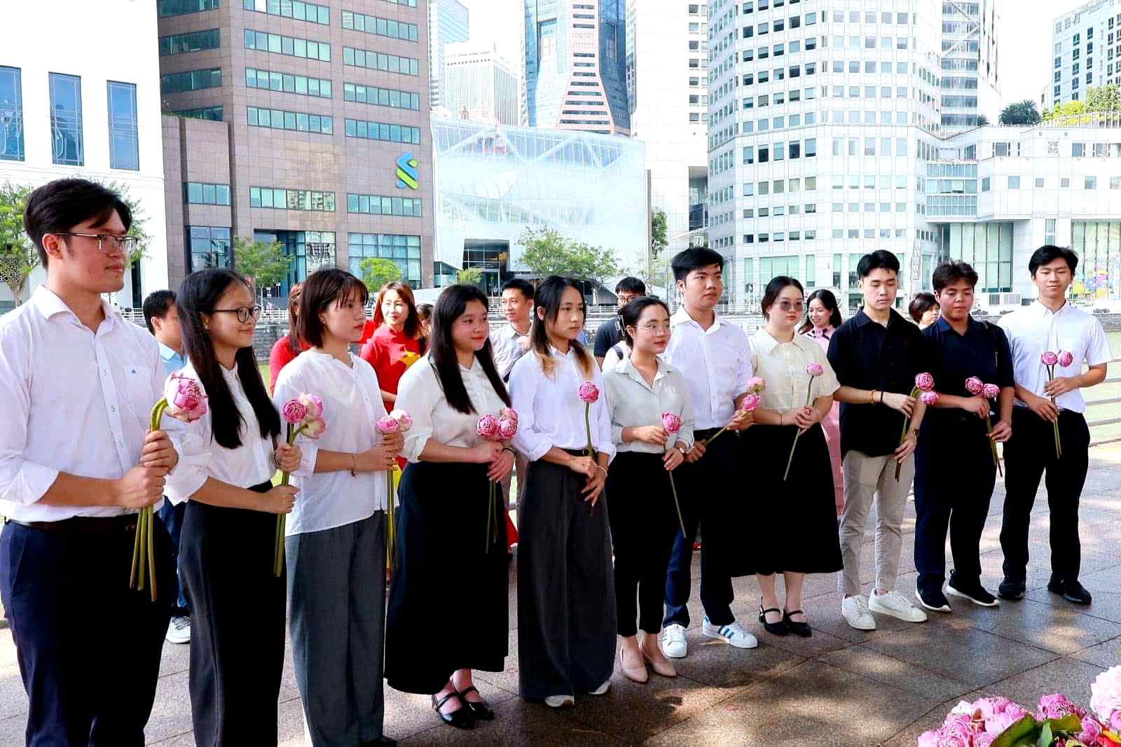 Lưu học sinh thành kính làm nghi lễ dâng hoa sen lên tượng đài Chủ tịch Hồ Chí Minh - Ảnh: NVCC