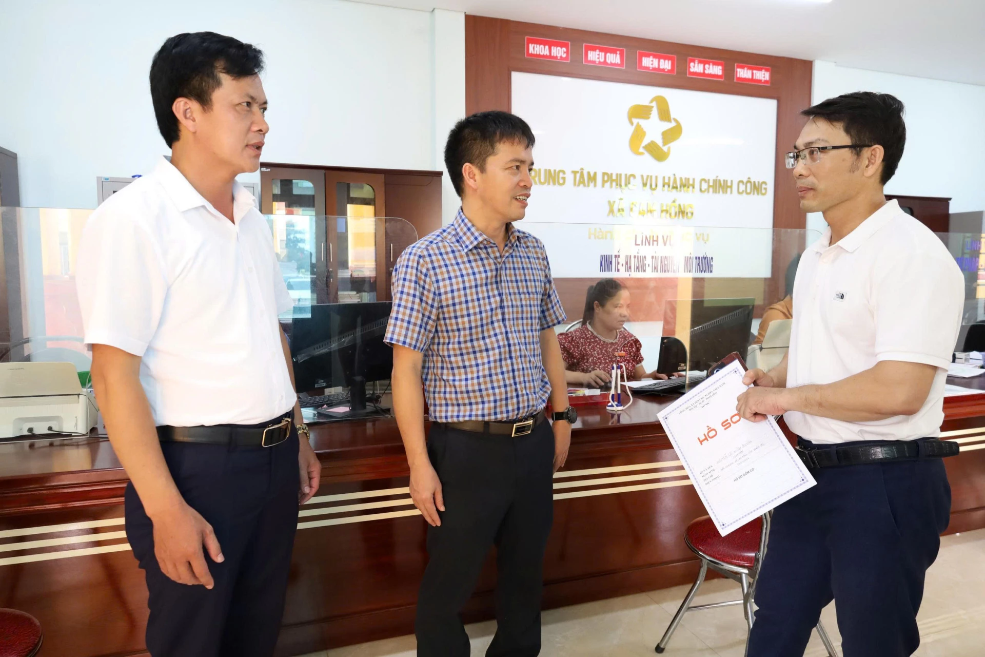 Lãnh đạo xã Cam Hồng trò chuyện với người dân đến giao dịch tại Trung tâm Phục vụ hành chính công -Ảnh: Q.N