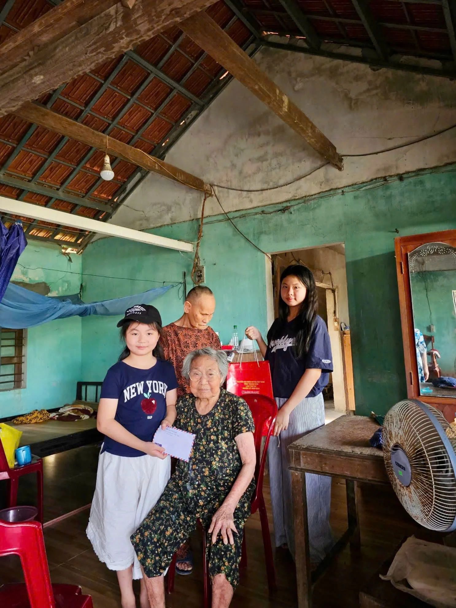 Hà Linh và Mai Khanh trao quà cho người gặp hoàn cảnh khó khăn - Ảnh: NVCC