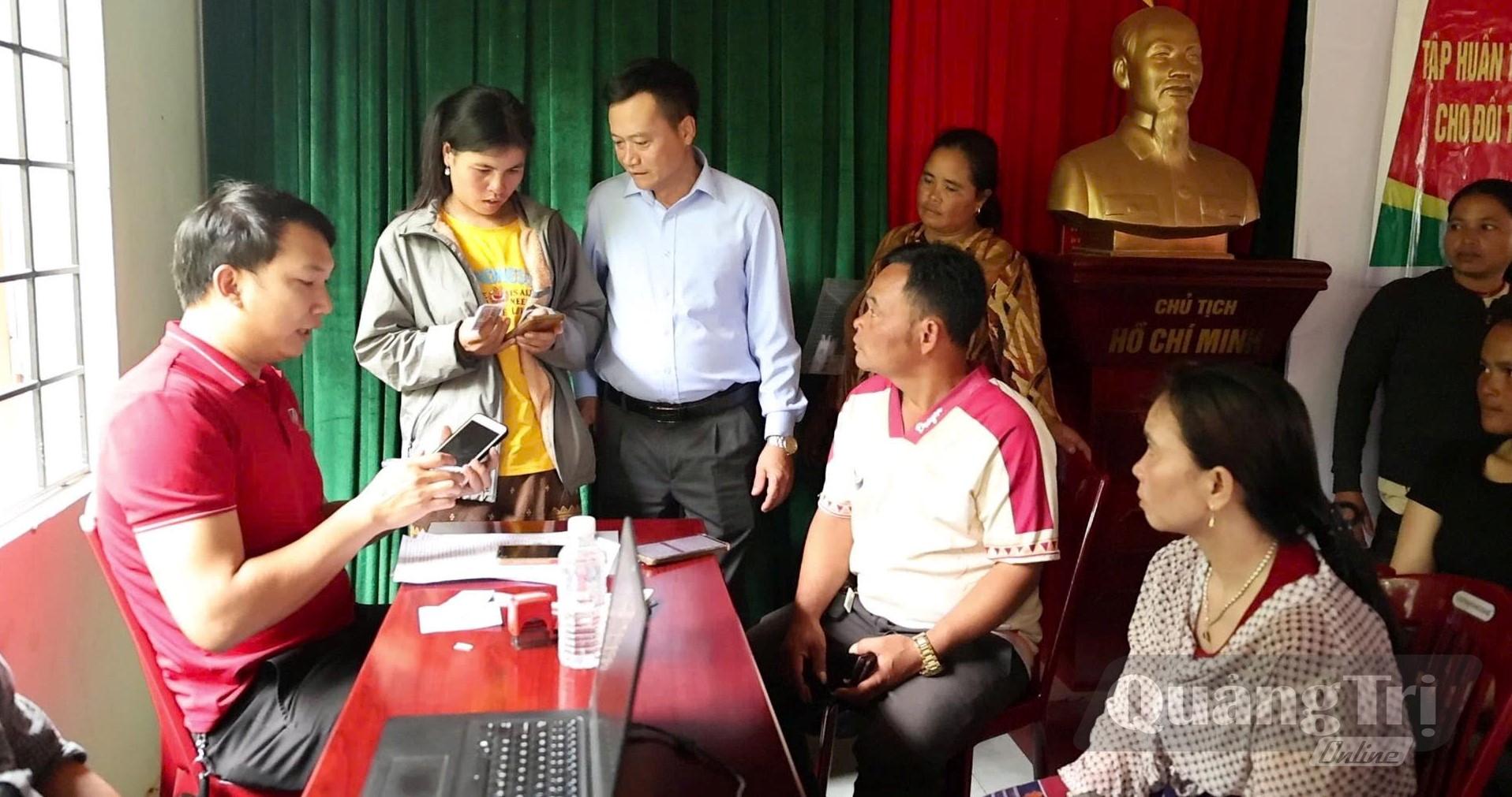 Tổ Đề án 06 xã A Dơi hướng dẫn người dân thôn Xy thực hiện các theo tác trên ứng dụng VNeID - Ảnh: K.H