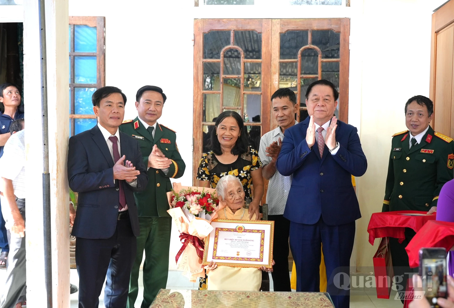 Đồng chí Đại tướng Nguyễn Trọng Nghĩa, Chủ nhiệm Tổng cục Chính trị Quân đội Nhân dân Việt Nam trao huy hiệu 80 năm tuổi Đảng cho đảng viên Trần Thị Trình, ở xã Lệ Thủy - Ảnh: T.Đ