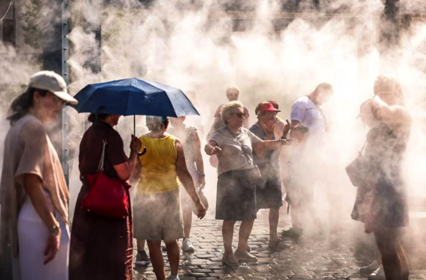Người dân làm mát dưới hệ thống phun sương ở Budapest, Hungary. THX/TTXVN phát
