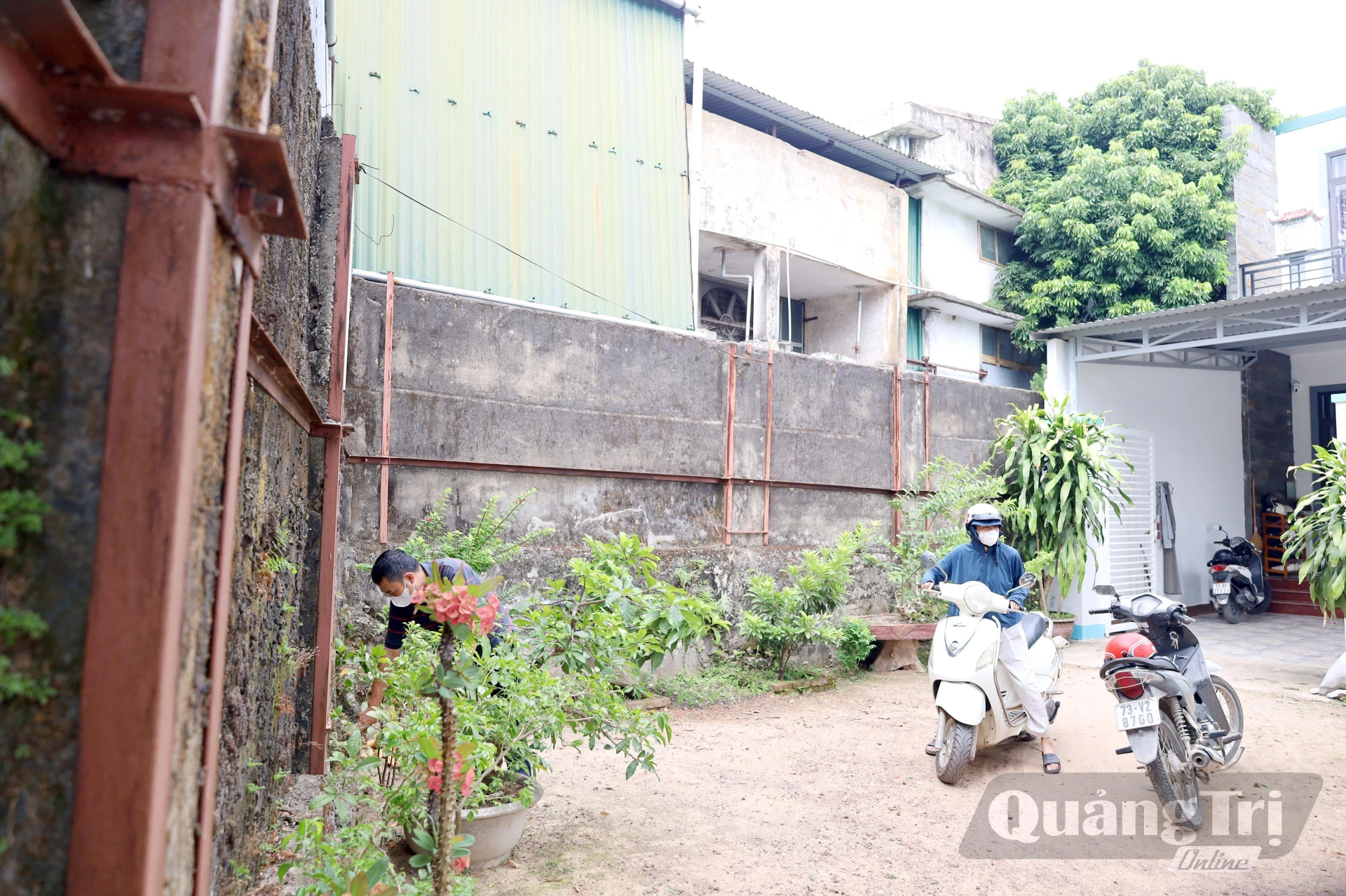 Gia đình ông Hà Ngọc Trung hàng ngày đều sinh hoạt cạnh tường rào băng bó của Nhà máy Bao bì Nhật Lệ, rất nguy hiểm - Ảnh V. Minh