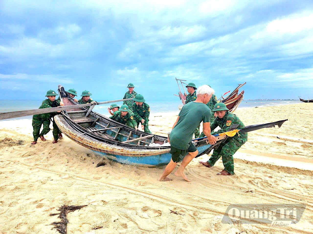 Cán bộ, chiến sĩ Đồn Biên phòng Hải An giúp ngư dân đưa tàu thuyền lên bờ, chủ động phòng, chống mưa bão - Ảnh: Quang Ngọc