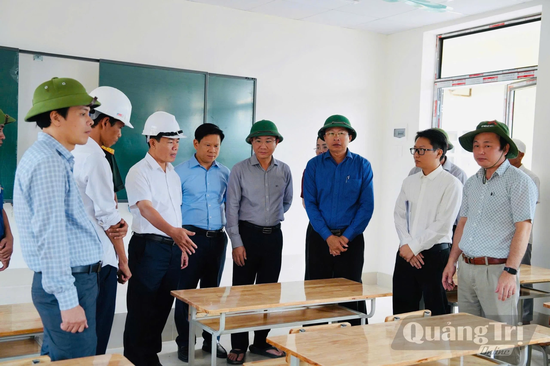 Lãnh đạo Ban Quản lý Dự án báo cáo tình hình lắp đặt thiết bị nội thất và trang thiết bị phục vụ sinh hoạt nội trú trong một phòng học Trường nội trú tiểu học và THCS Hướng Phùng - Ảnh: Mỹ Nhị