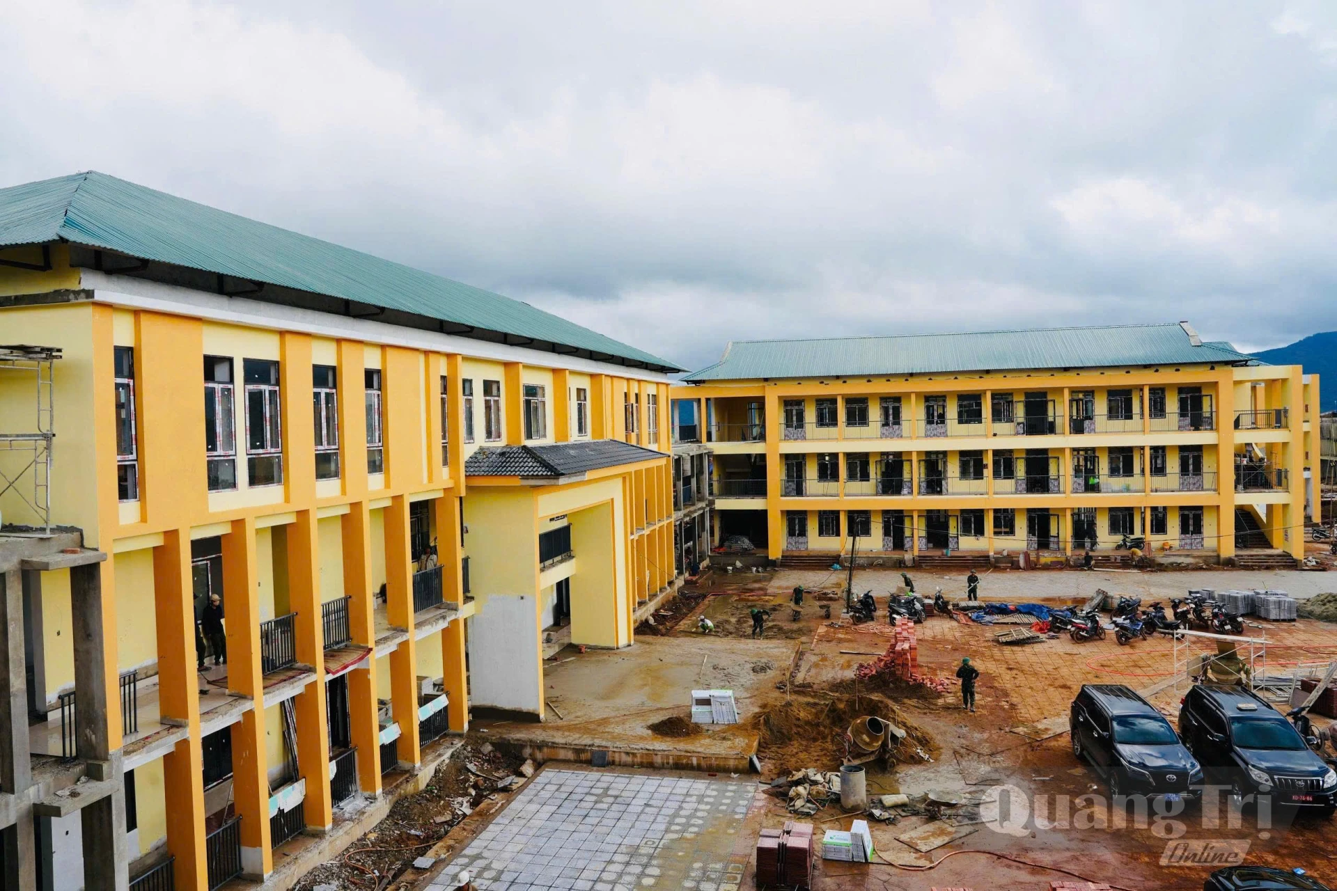 Toàn cảnh khối nhà học cao tầng thuộc dự án Trường nội trú tiểu học và THCS Hướng Phùng, với khuôn viên sân trường đang được san gạt, lát gạch - Ảnh: Mỹ Nhị